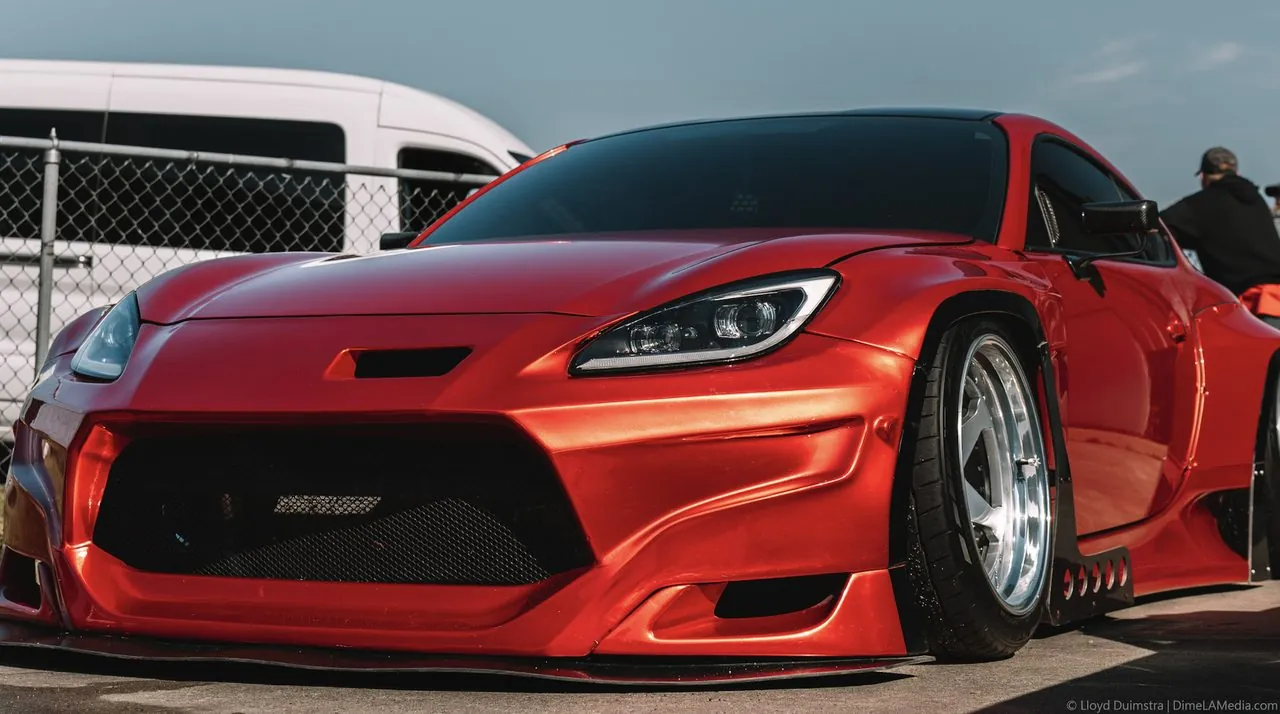 Widebody Toyota GR86 in candy red, slammed low at a South Dakota car meet