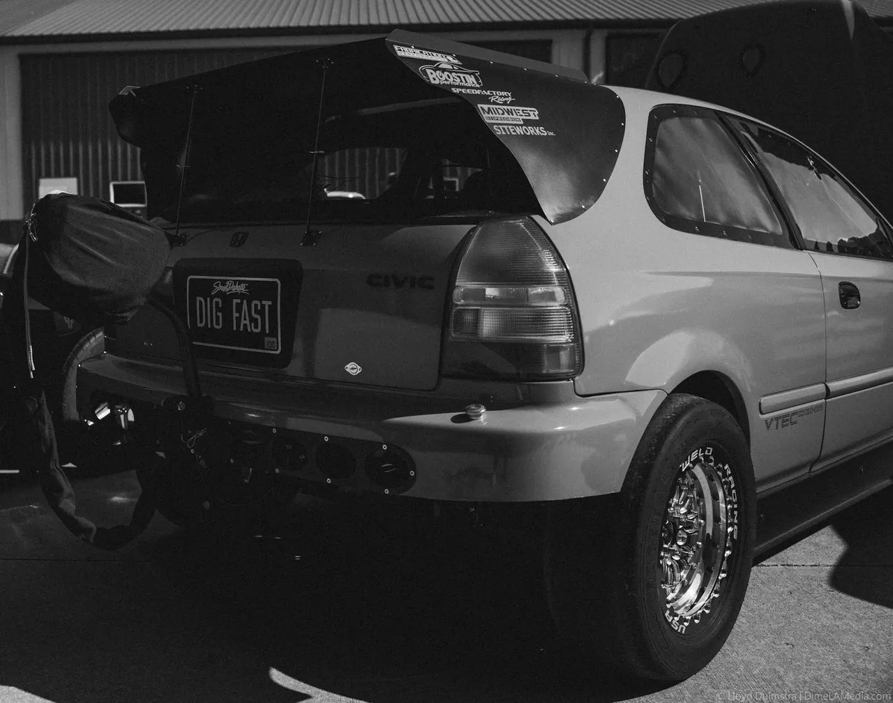 Black and white photo of a drag-prepped Honda Civic hatchback with a tall wing