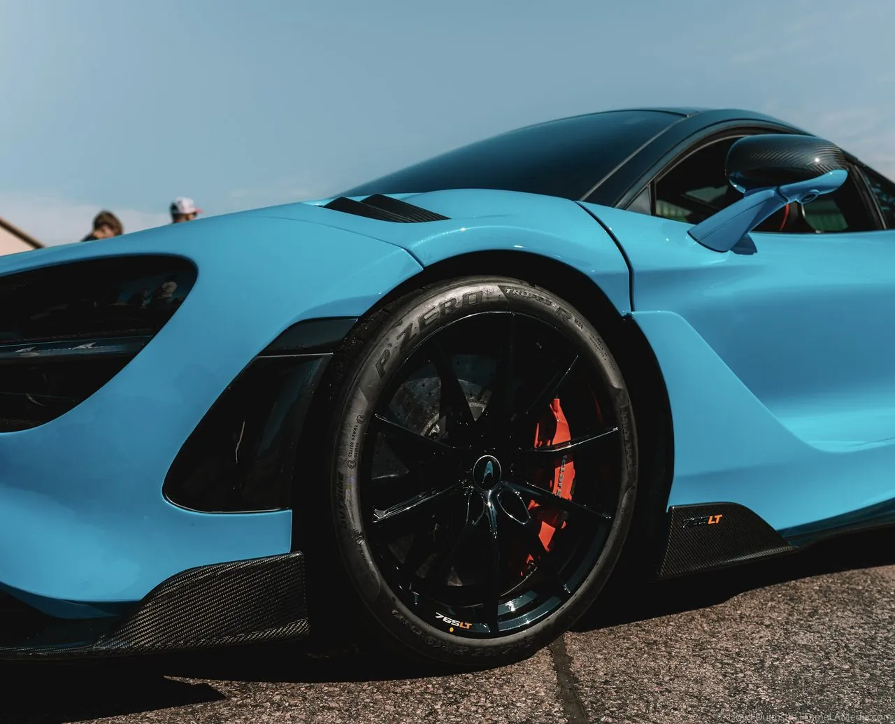 Sky-blue McLaren 765LT side profile and forged wheel at a track day
