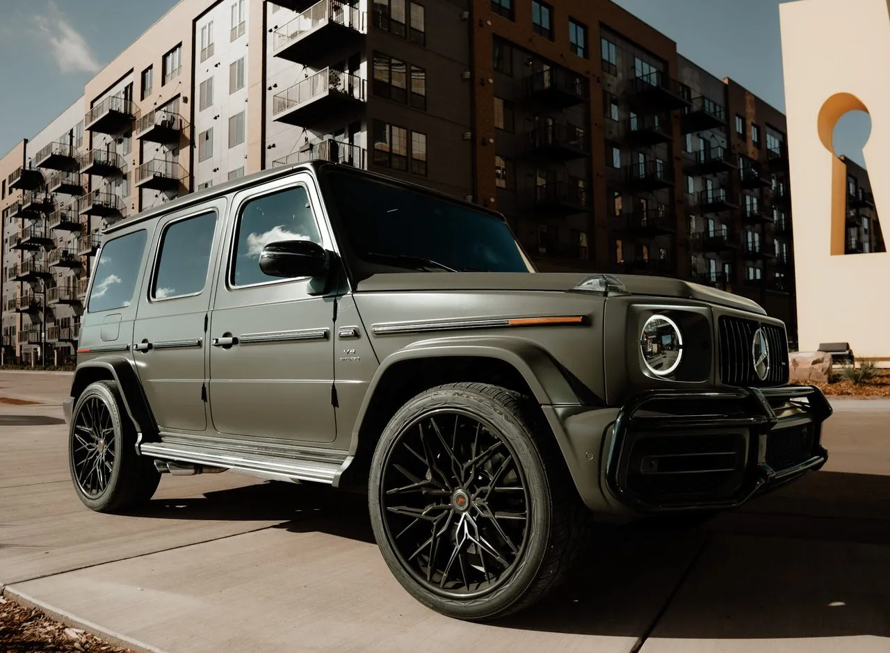 Matte grey Mercedes-AMG G63 in front of a downtown apartment block