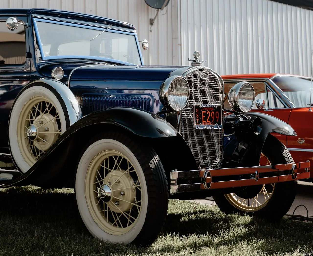 Restored 1931 Ford Model A in navy with cream spoke wheels at a car show