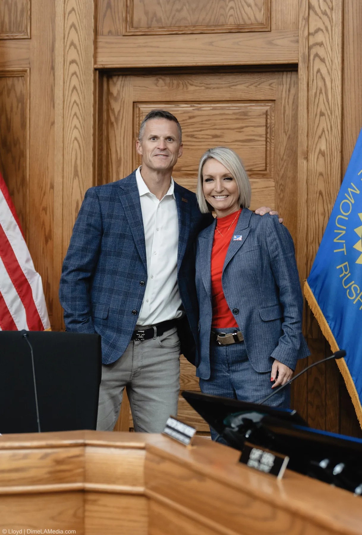 Paul TenHaken and Christine Erickson pose together at the dais beside the South Dakota flag
