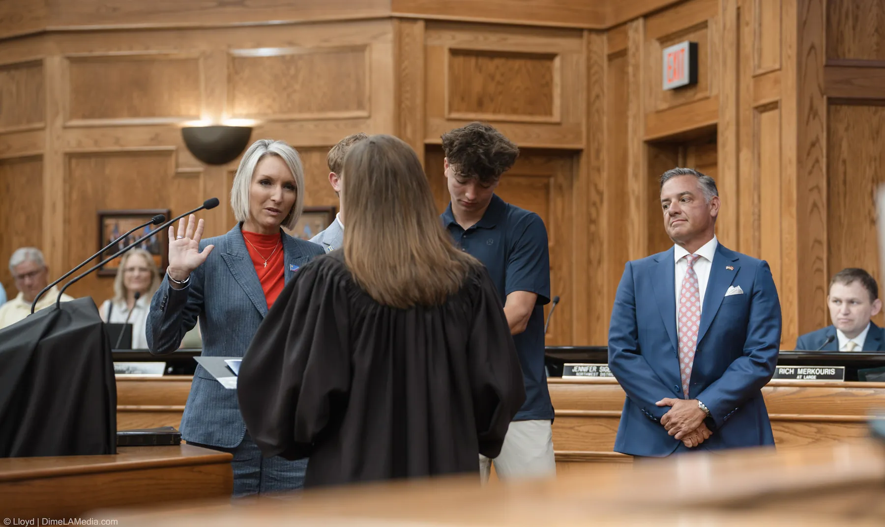 Christine Erickson raises her right hand before the presiding judge as her family stands beside her at Carnegie Town Hall