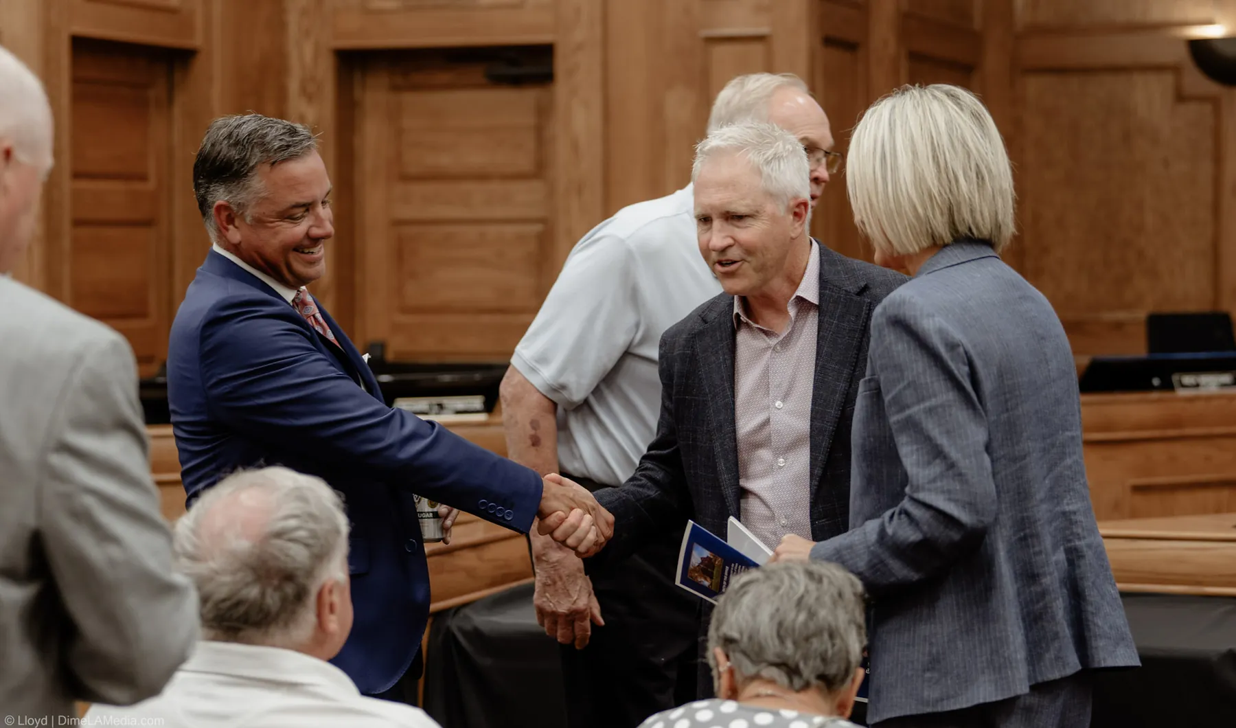 Handshakes and greetings between guests in the council chamber before the inauguration