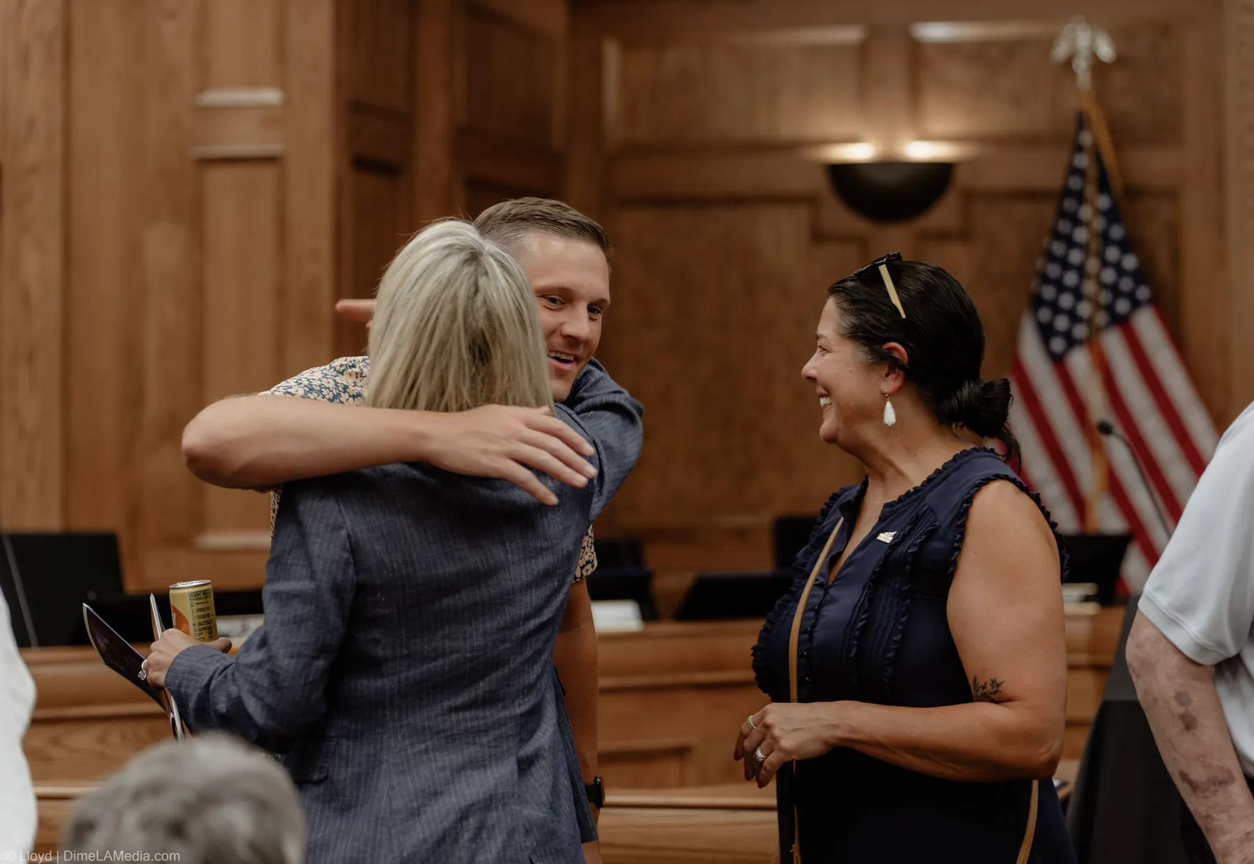 Christine Erickson embraces a supporter beside the American flag before taking the oath
