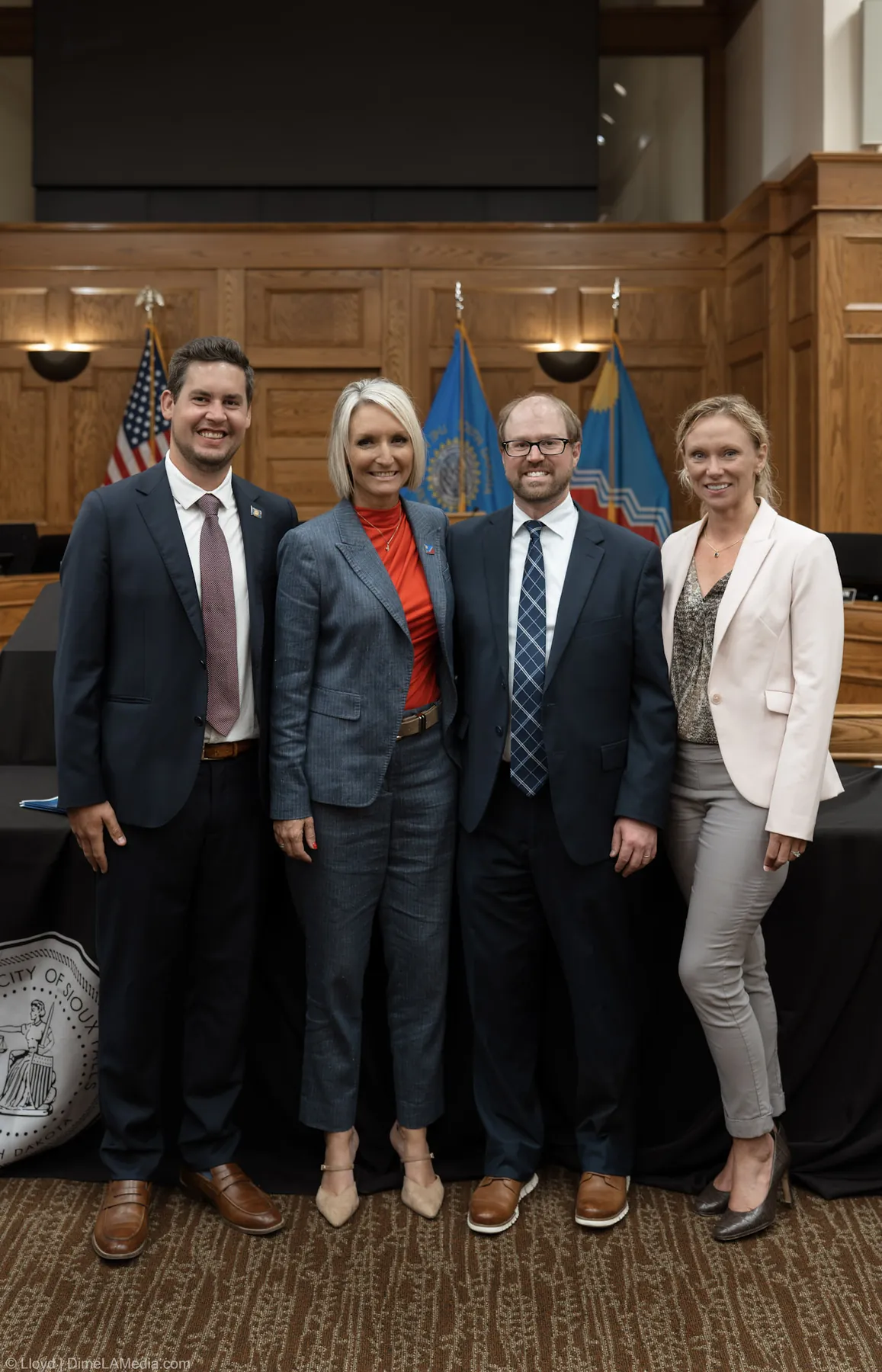 Mayor Christine Erickson with guests beside the City of Sioux Falls seal after the ceremony