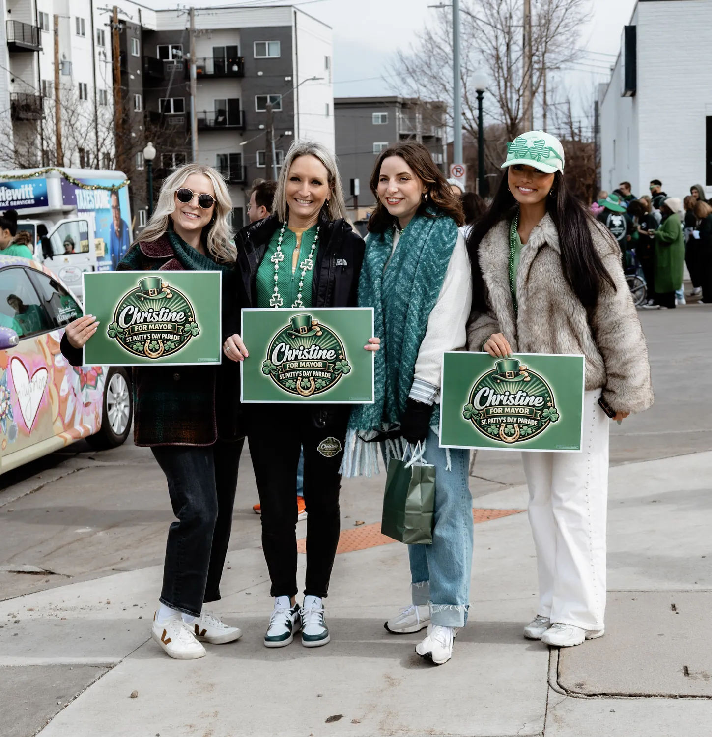 Supporters hold green Christine for Mayor signs at the St. Patrick's Day parade in Sioux Falls