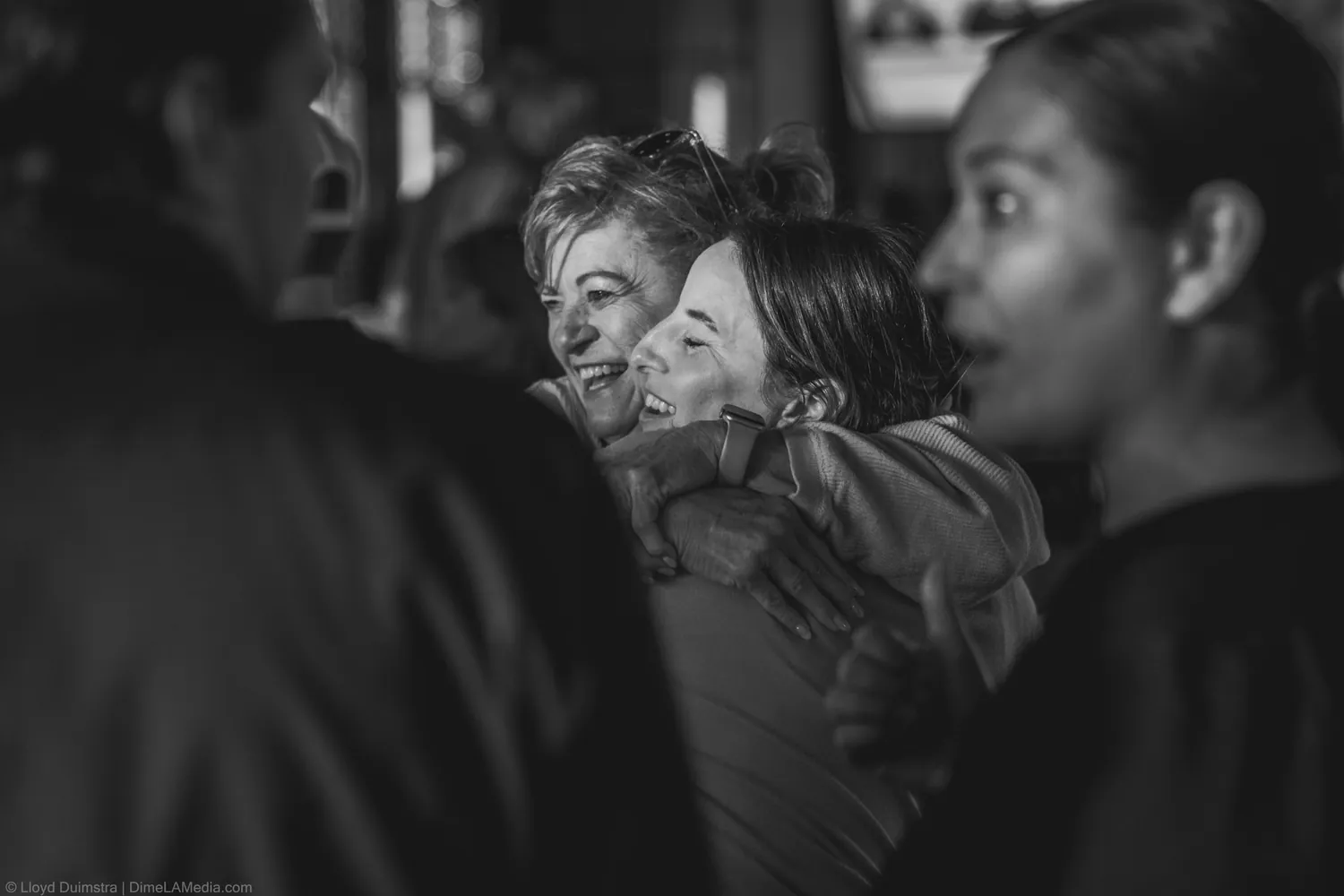 Black and white moment of two supporters embracing at the watch party