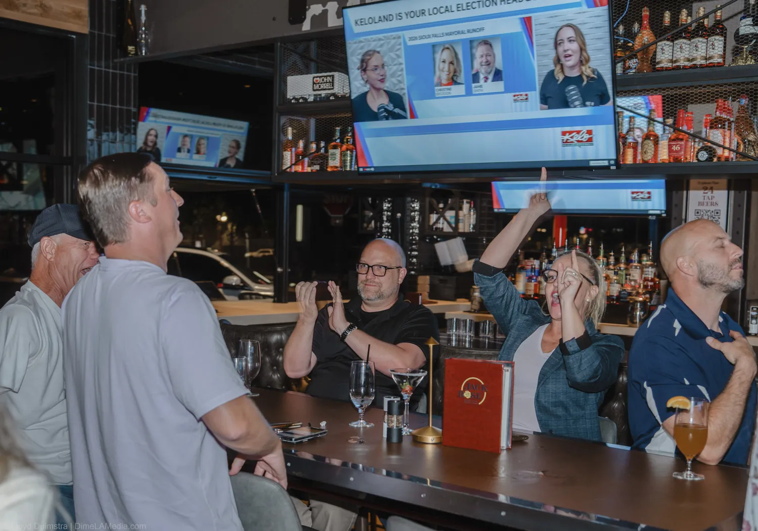 The crowd watches election returns on the screens and applauds at the Christine Erickson watch party