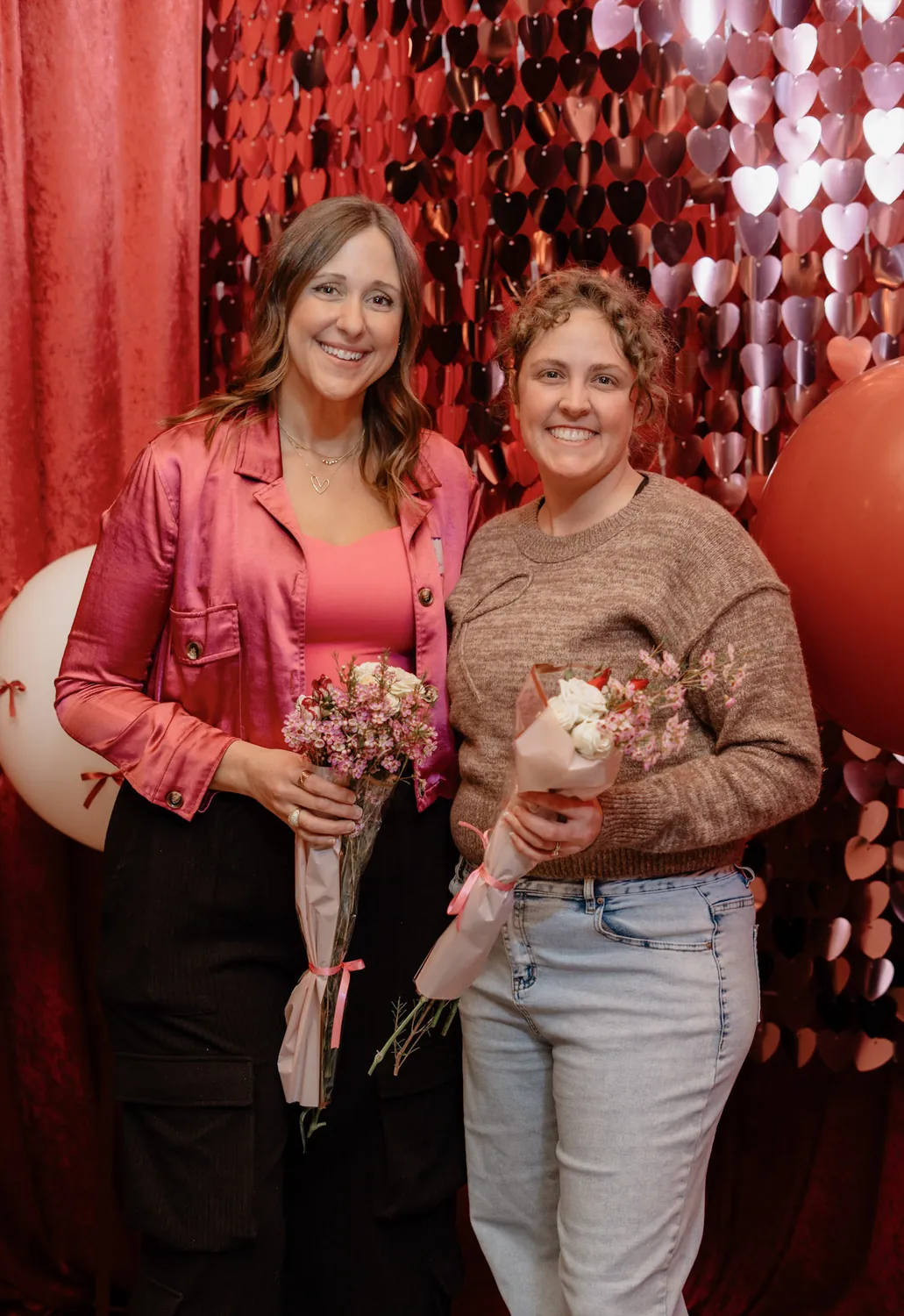 Two guests with flower bouquets at a Christine Erickson community event in Sioux Falls