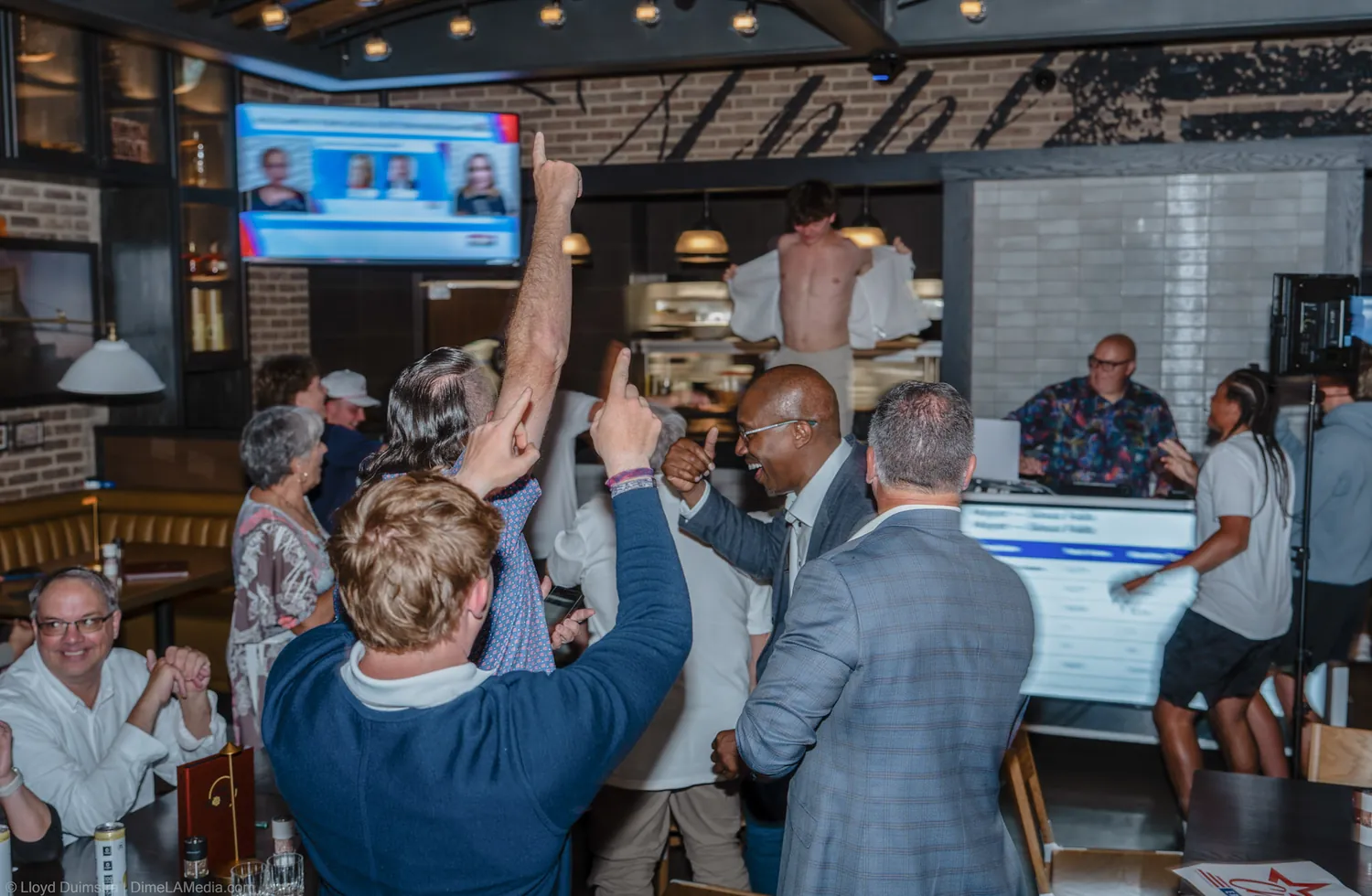 Supporters raise their arms as results favor Christine Erickson on election night