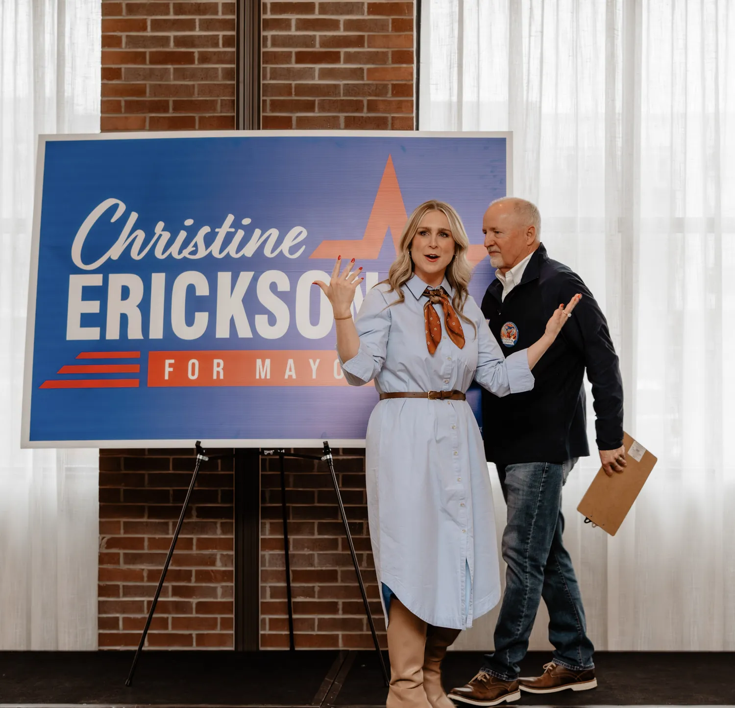 Christine Erickson greets a supporter beside her campaign sign at a Sioux Falls event