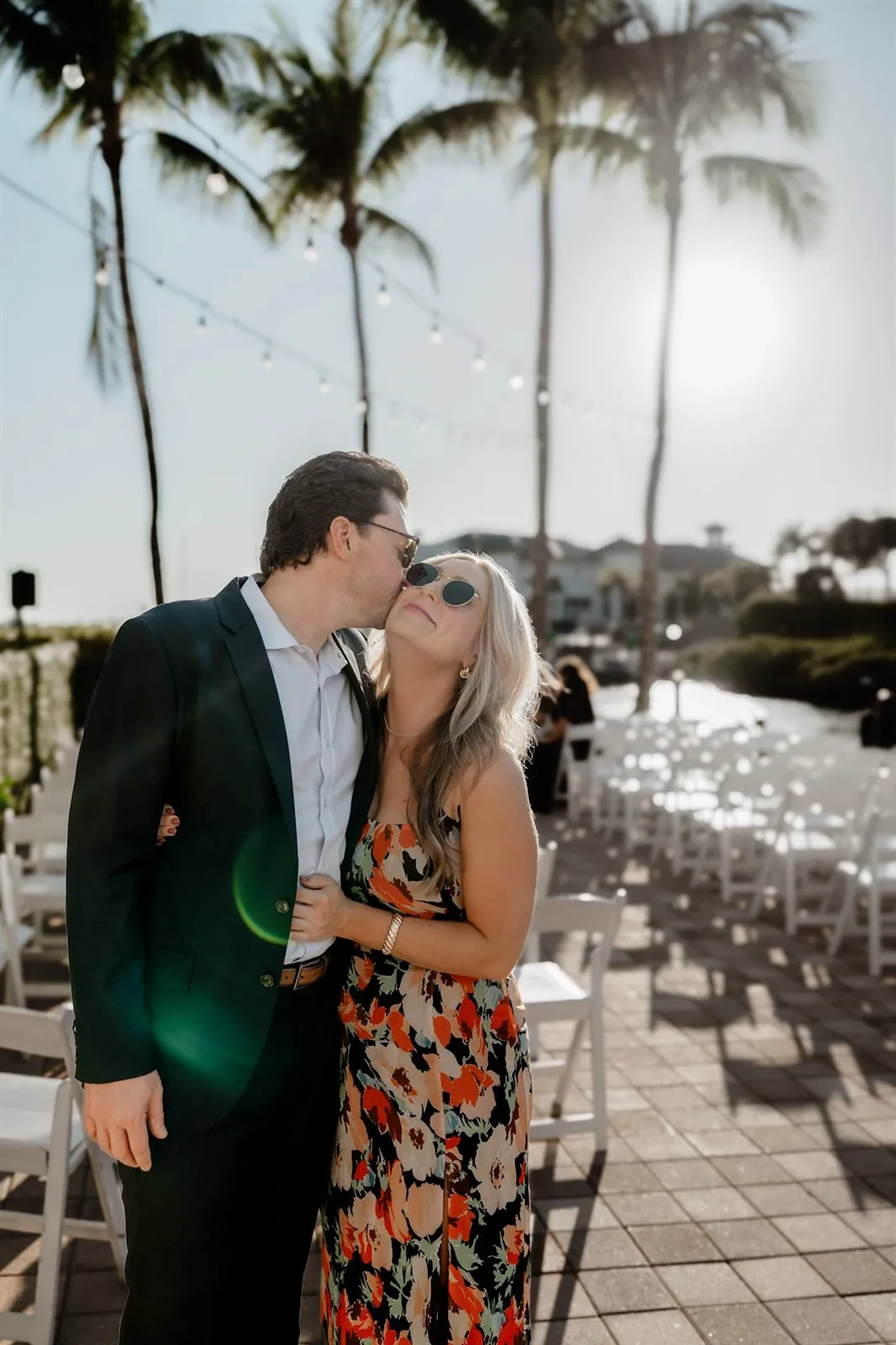 Couple embracing at a sunny palm-lined outdoor venue