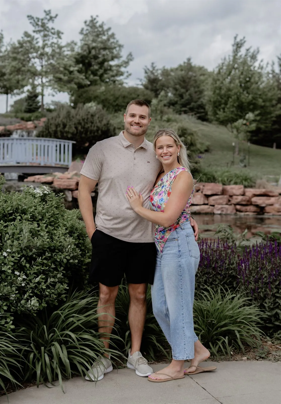 Portrait of a newly engaged couple smiling in a garden