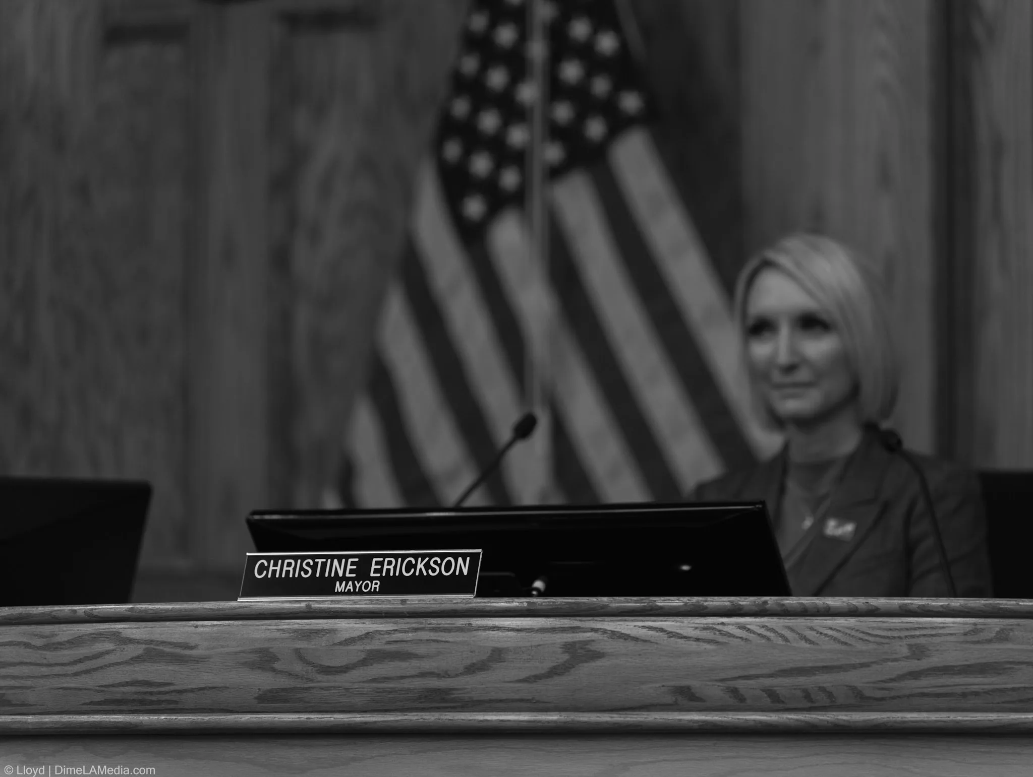 Christine Erickson soaking in her first minutes seated as Mayor of Sioux Falls behind her nameplate, photographed by Lloyd Duimstra