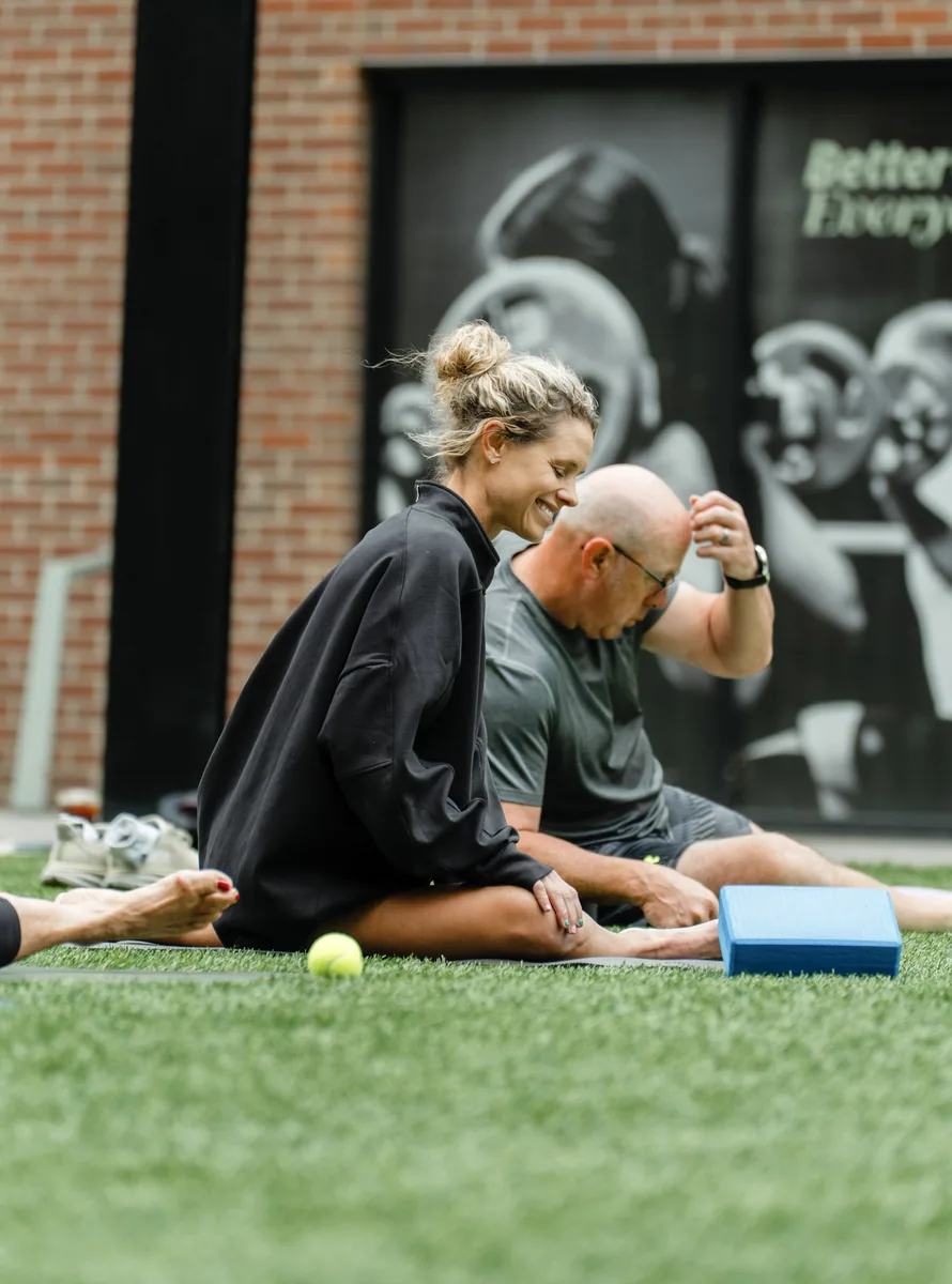 Two participants laughing between rounds at the Sisu and Pomegranate Market Kinstretch class, Sioux Falls SD