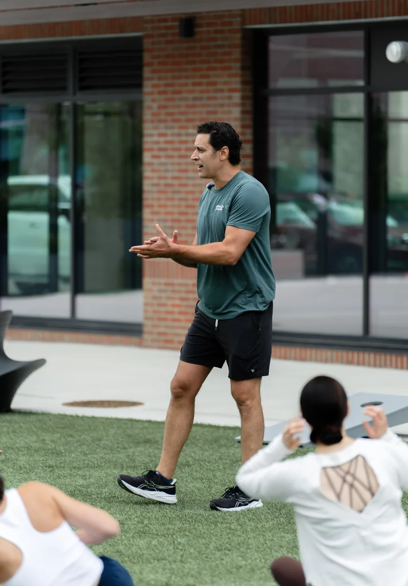 A Sisu coach talking the class through the next round of the outdoor Kinstretch session, Sioux Falls SD