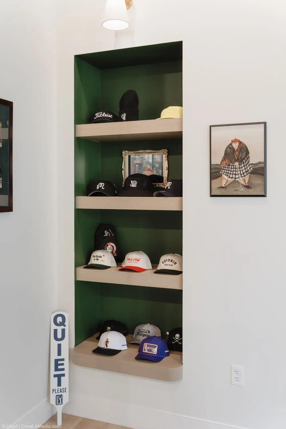 Hat shelves and framed art in a green alcove at Final Drive