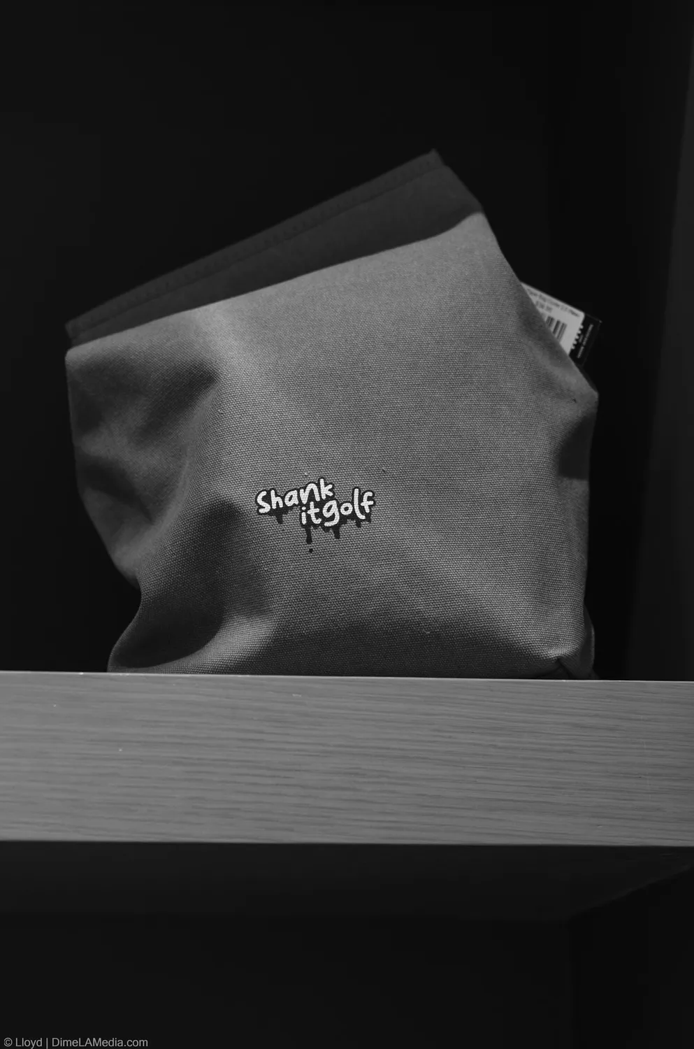 Black and white detail of a golf accessory pouch on display at Final Drive