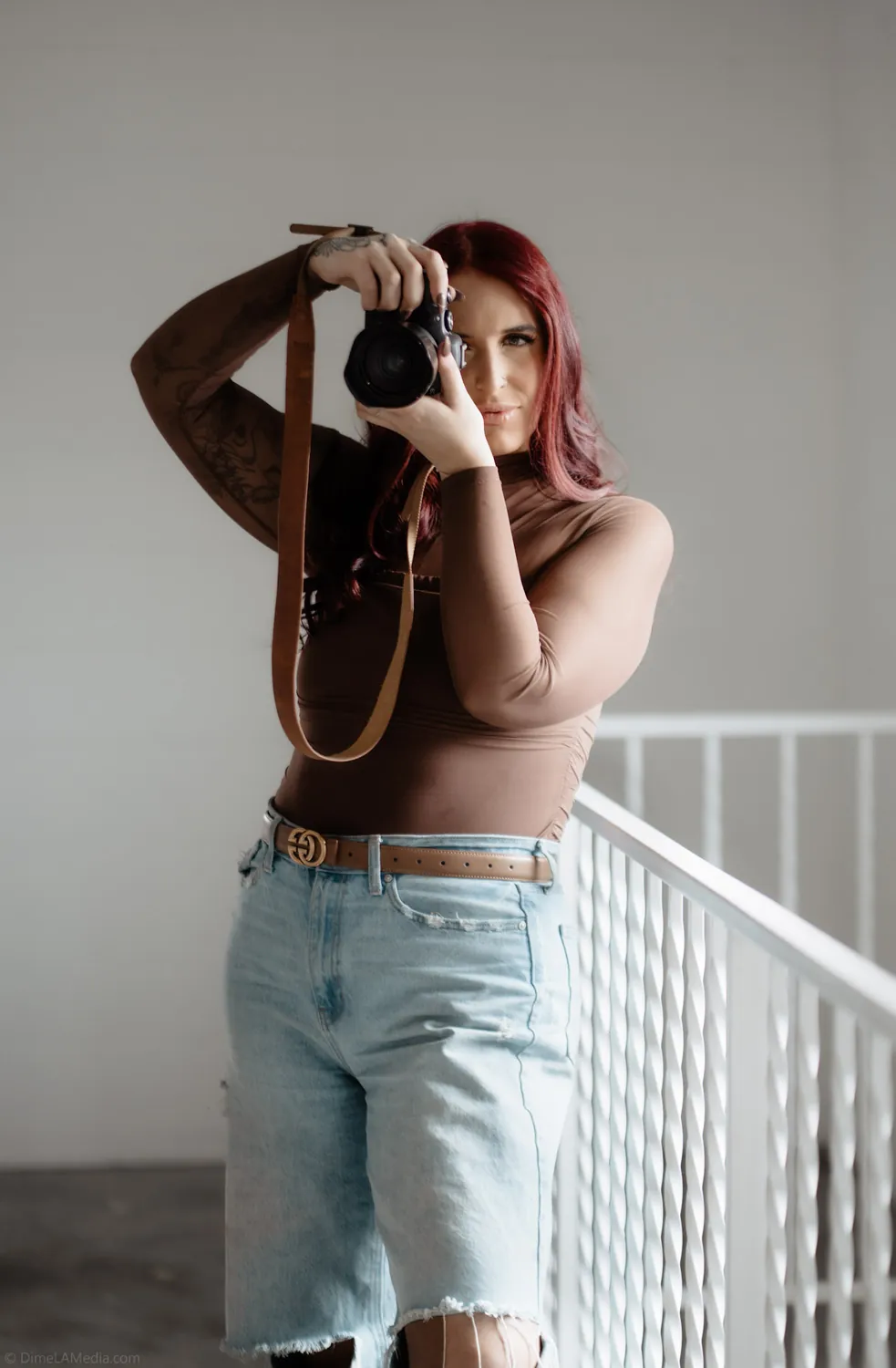 Jade raises her camera to shoot during a personal branding session in a Sioux Falls studio