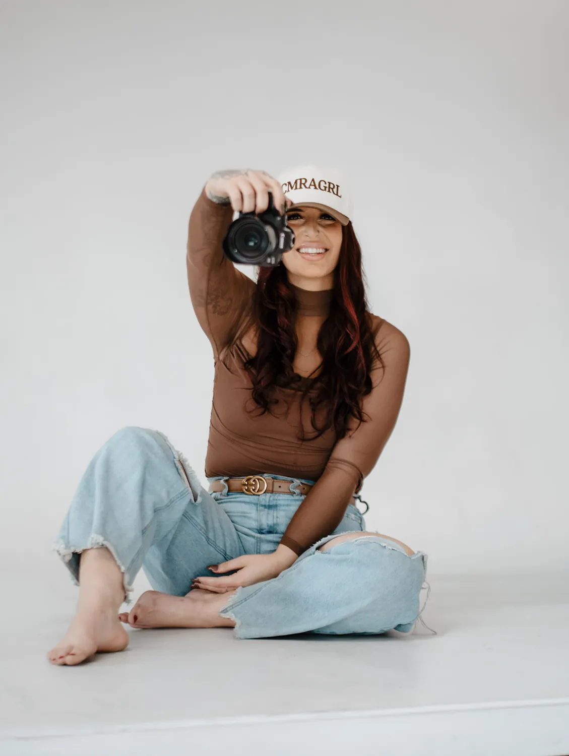 Jade points her camera at the viewer during a studio branding shoot in Sioux Falls