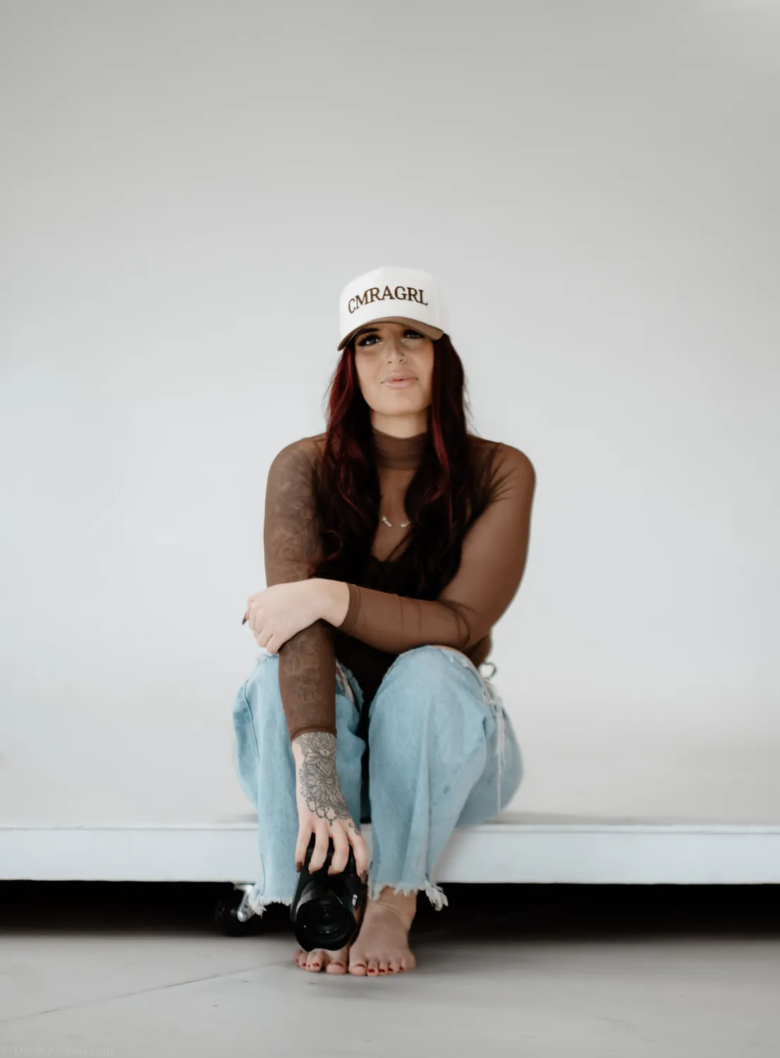 Jade adjusts her camera with her hat pulled low during the studio session