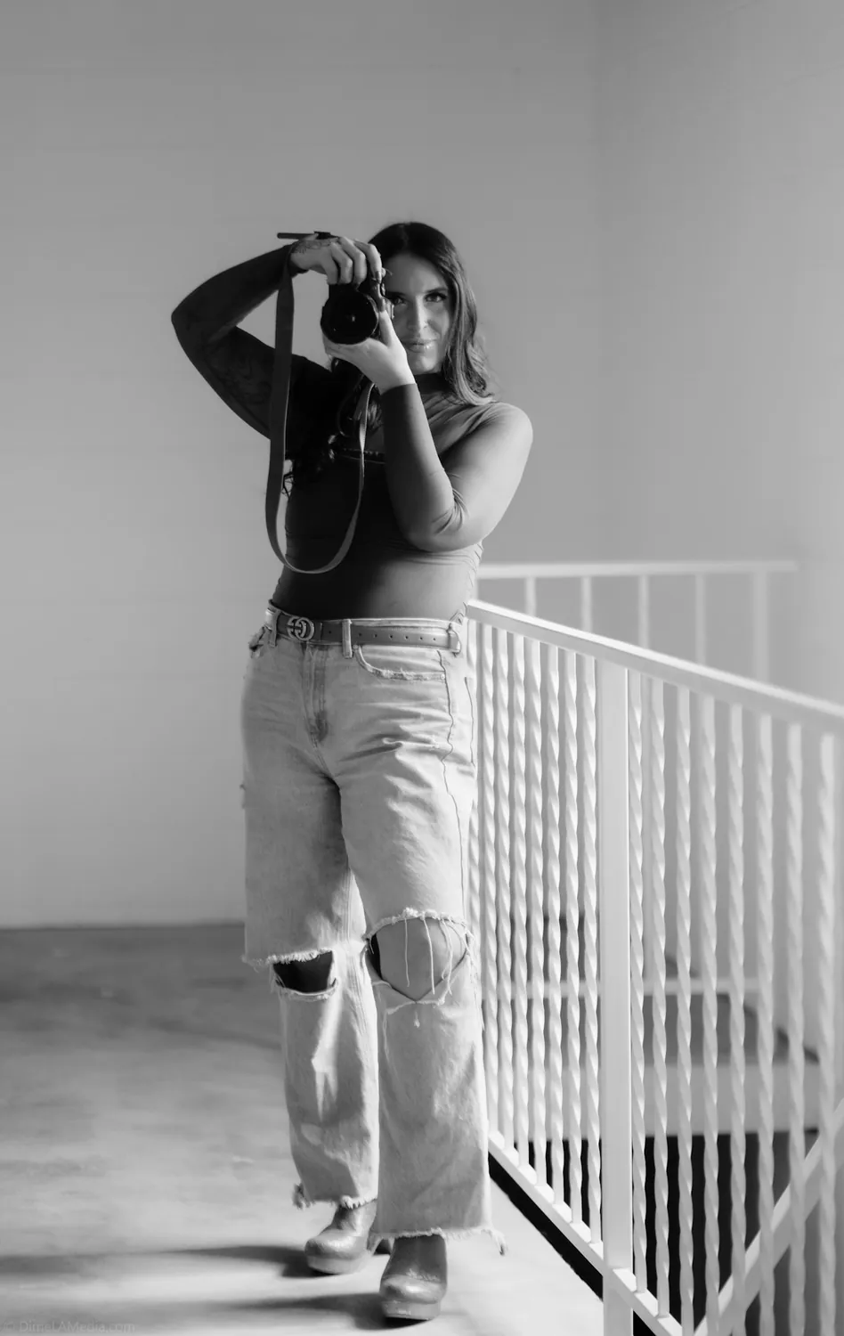 Black and white frame of Jade shooting from the studio mezzanine rail
