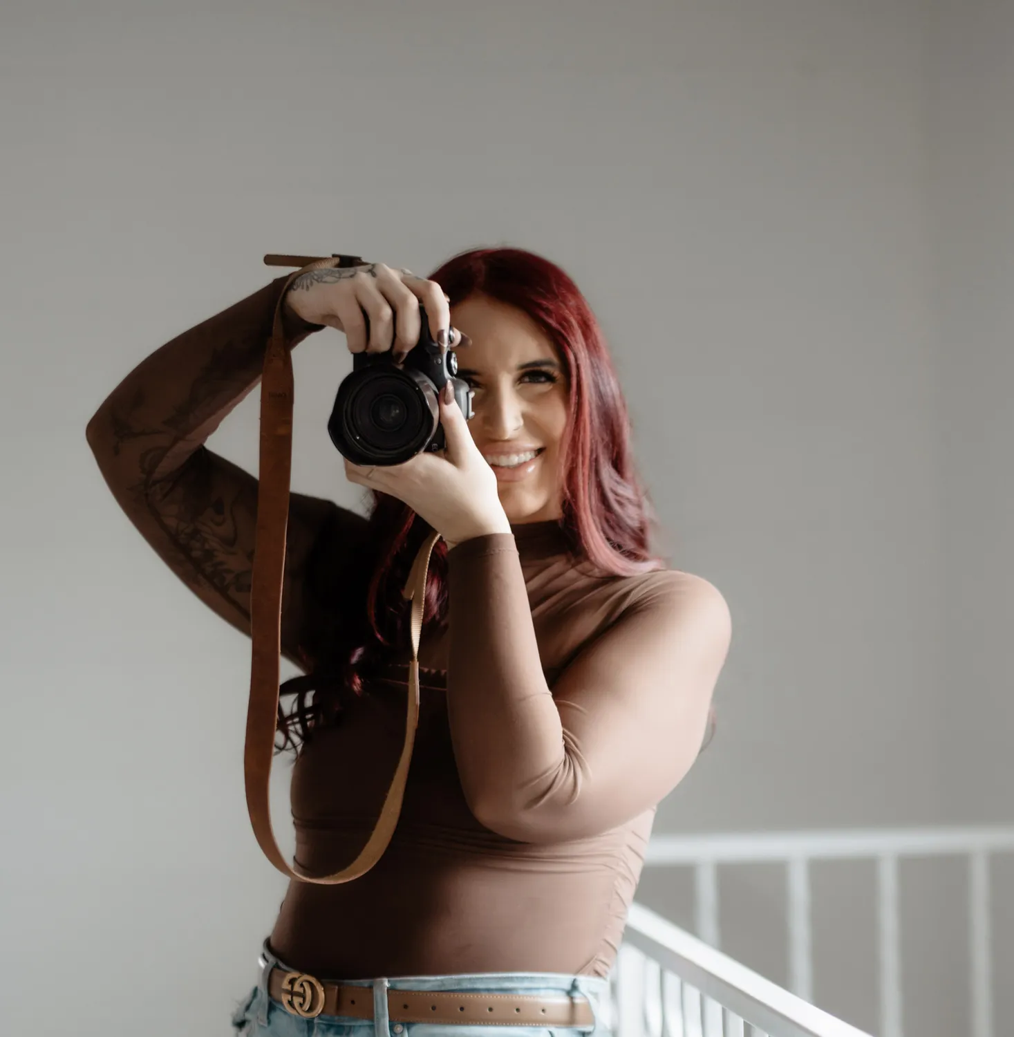 Jade smiles behind her camera during a studio personal branding session in Sioux Falls