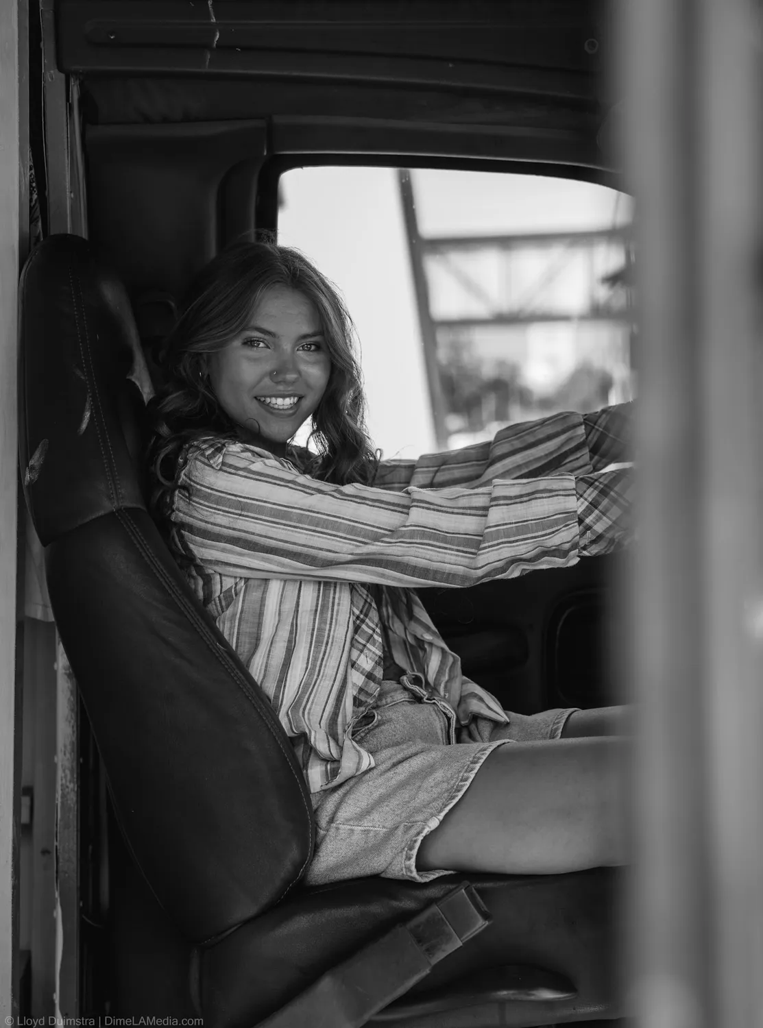 Black and white frame of Maddie Theisen in the driver seat of the True Vintage bus