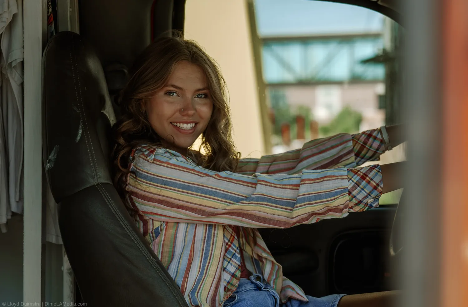 Warm portrait of Maddie Theisen in the cab of the True Vintage bus