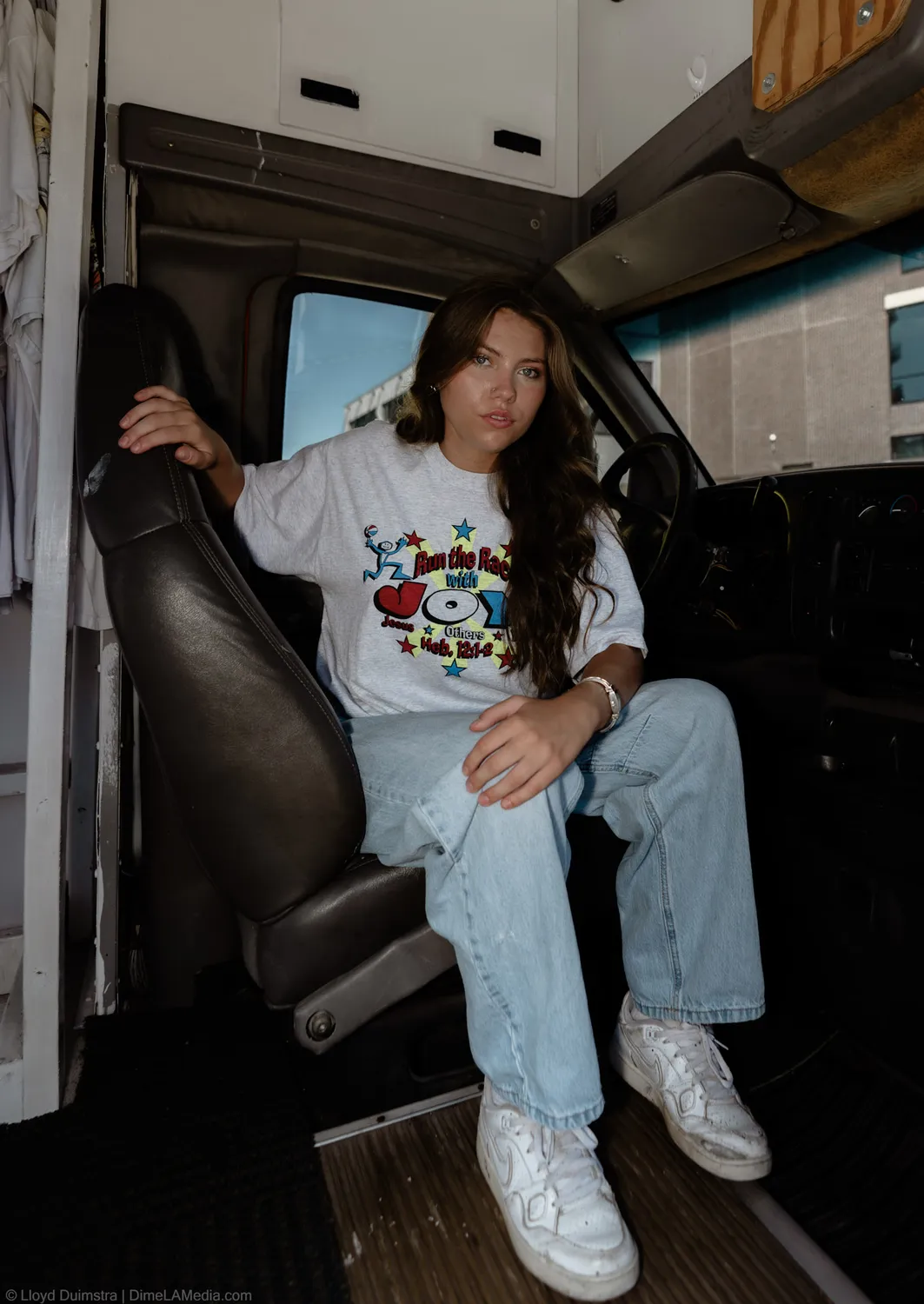 Black and white founder portrait of Maddie Theisen in the vintage chair inside her bus shop