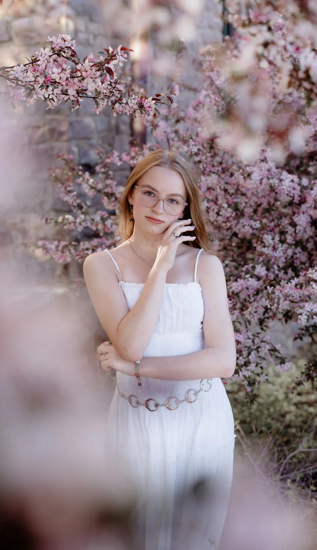 Senior portrait under blossoming spring trees