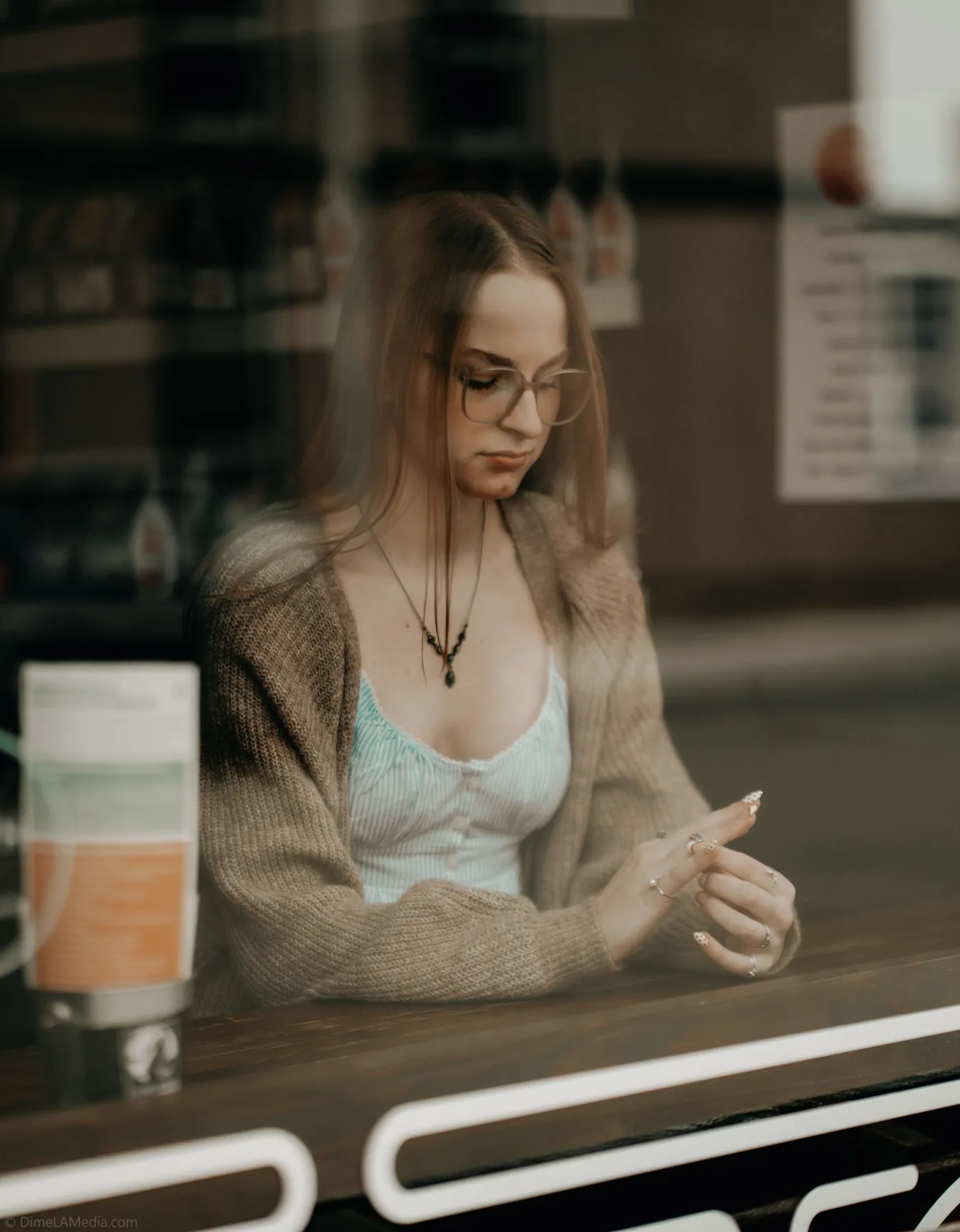 Syd Patzwald senior portrait through a cafe window, downtown Sioux Falls