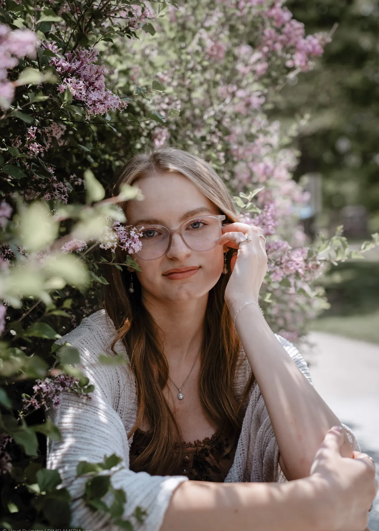 Syd Patzwald senior portrait framed by lilac blooms