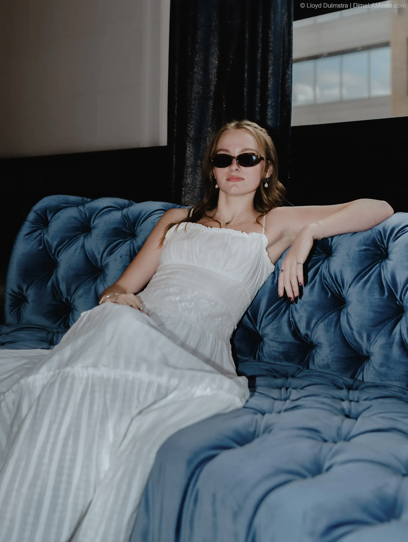 Syd Patzwald senior portrait on a vintage blue velvet couch