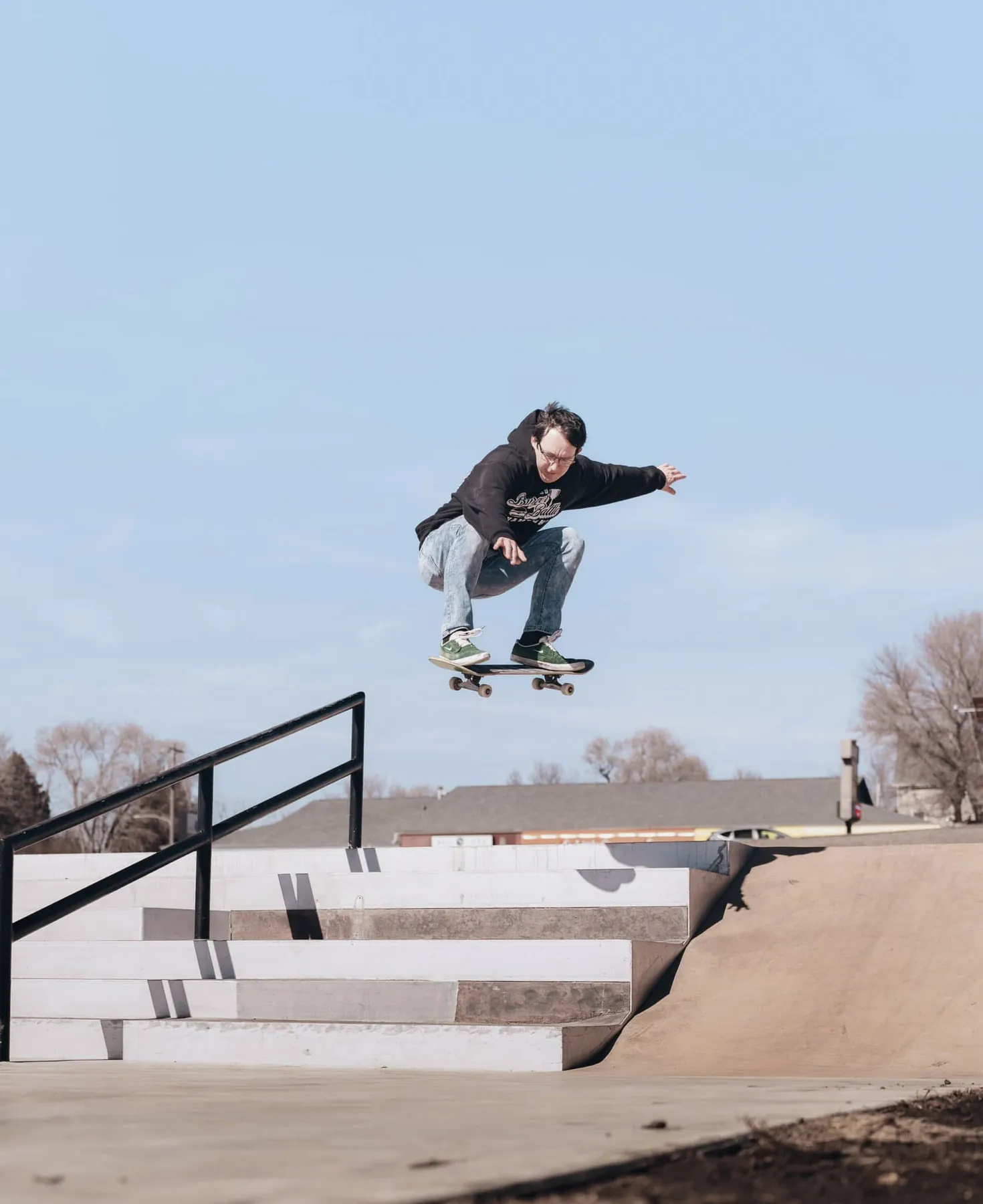 Skateboarder launching over a stair set at a Sioux Falls skatepark