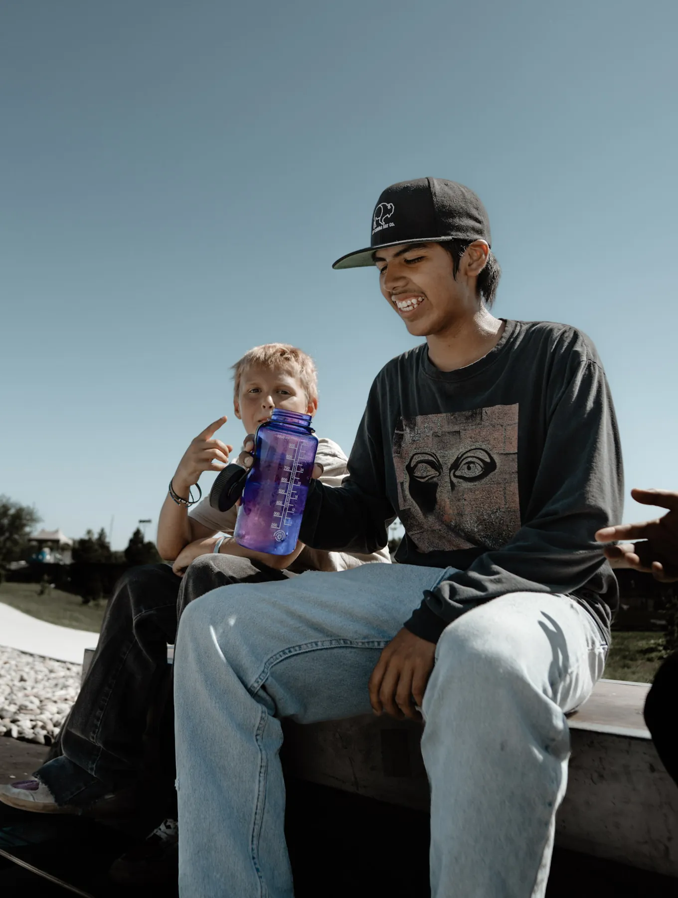 Skater taking a water break with a young fan