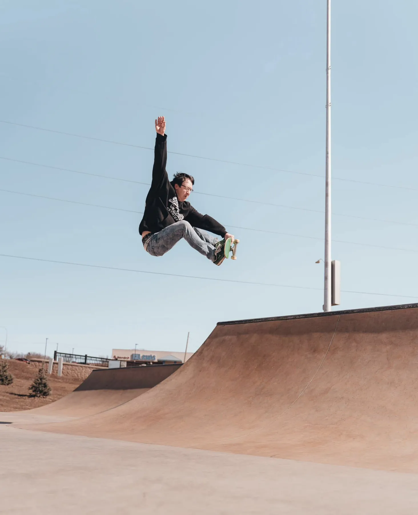 Skater grabbing his board mid-air over the ramp