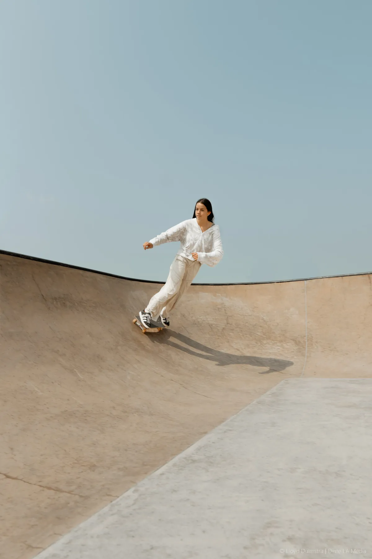 Skater carving down the bank of an outdoor bowl