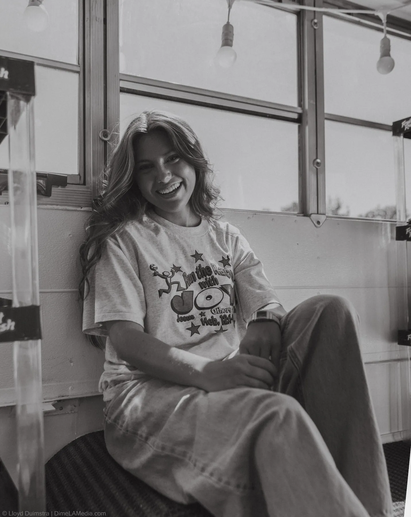 Black and white portrait of Maddie laughing inside the True Vintage bus