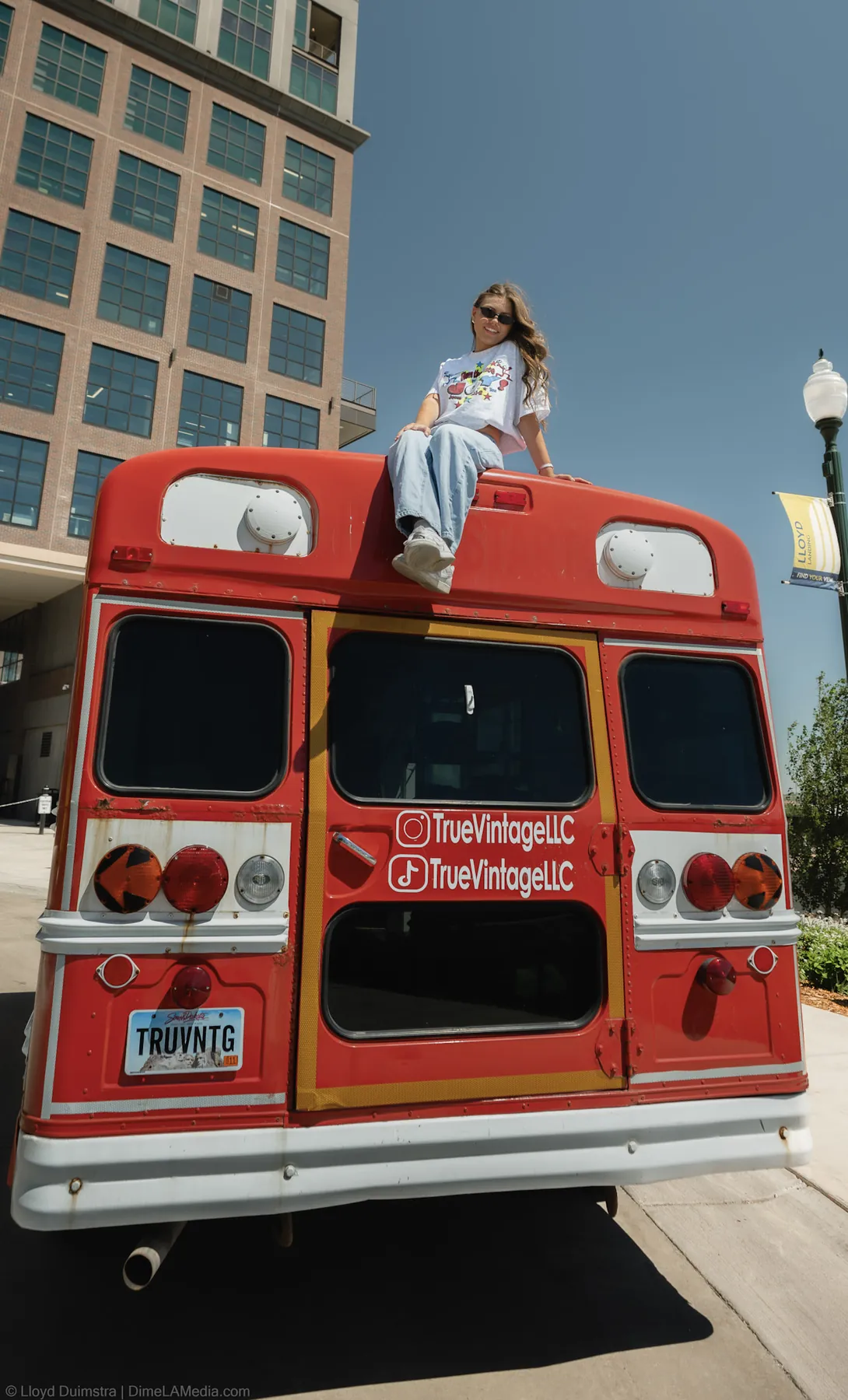 Maddie sitting on the roof of the red True Vintage bus, downtown Sioux Falls
