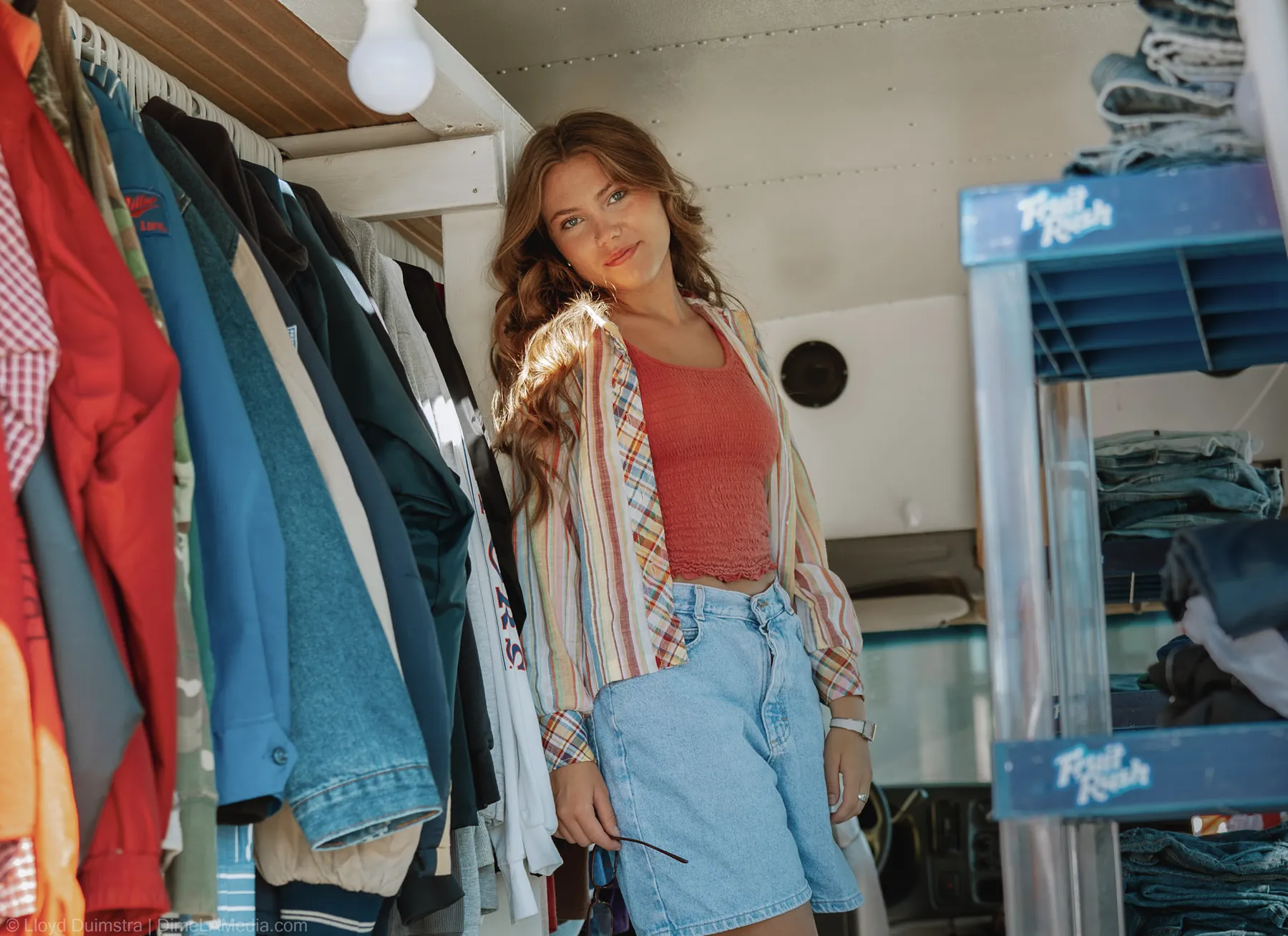 Maddie beside the denim racks inside the True Vintage LLC bus