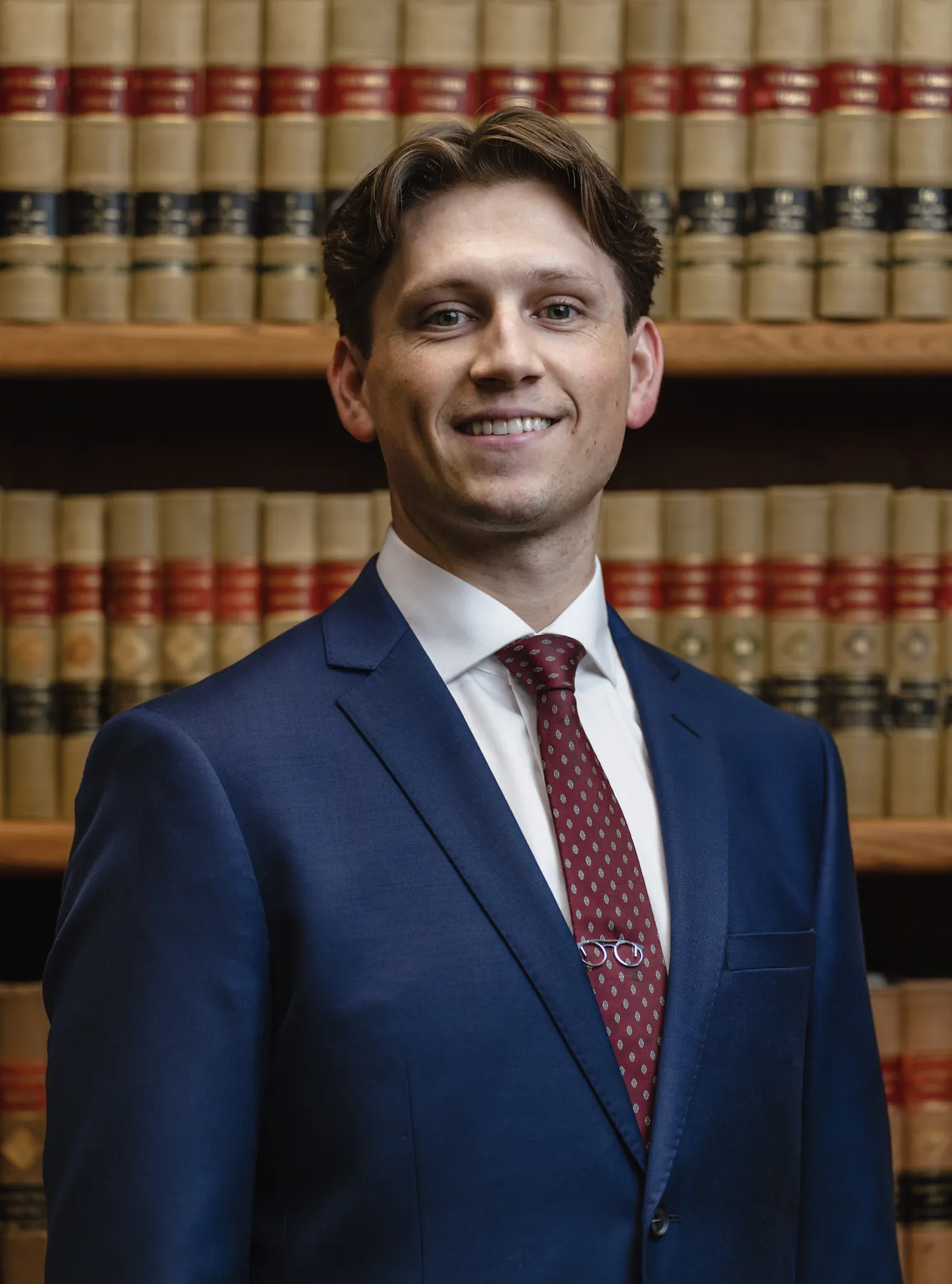 Professional headshot of an attorney in a navy suit and patterned tie