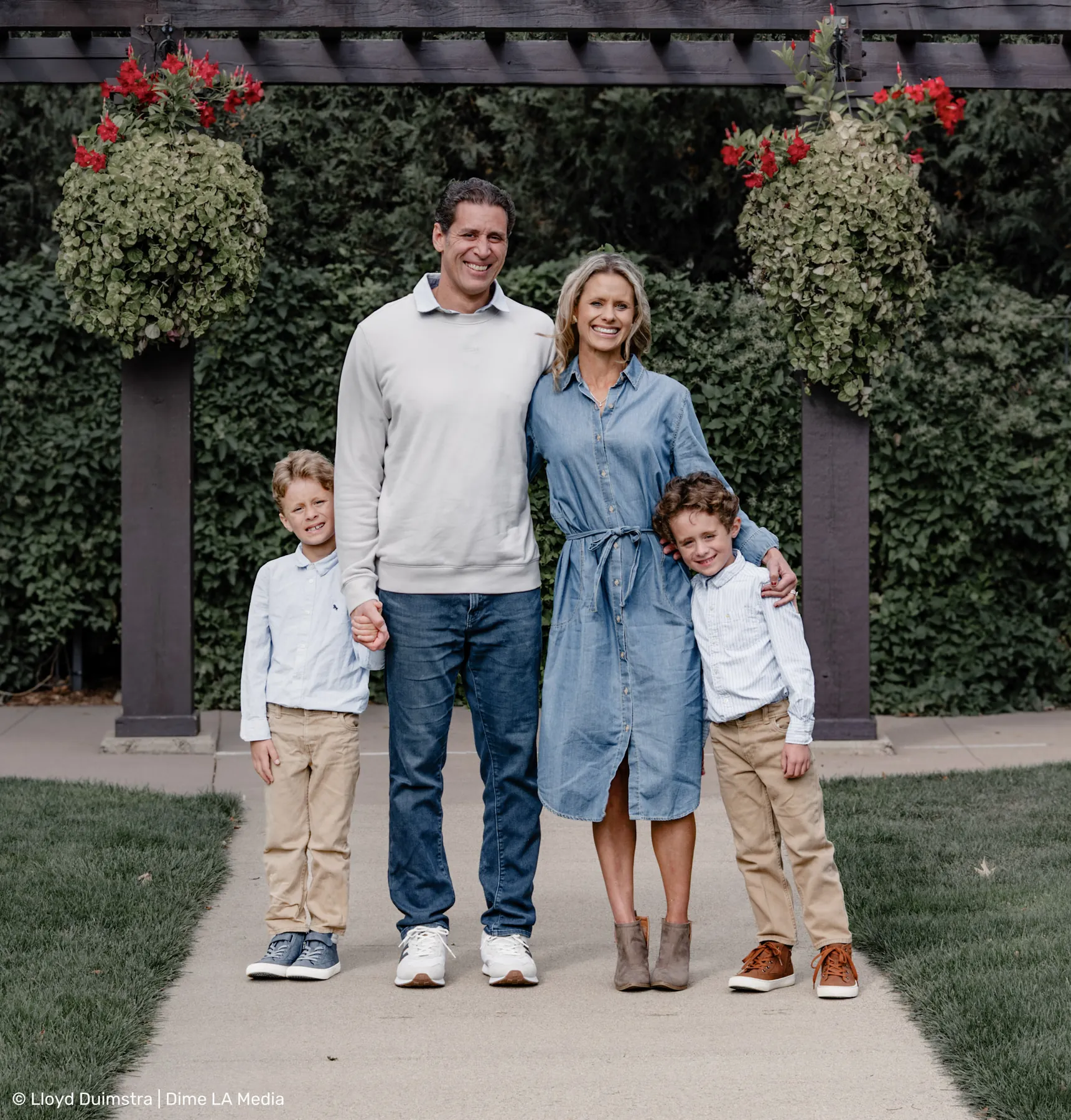 Family of four posed under a flowering pergola, Sioux Falls park