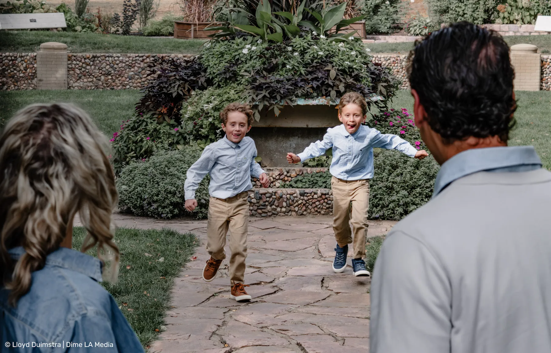 Two brothers racing up the path toward their dad