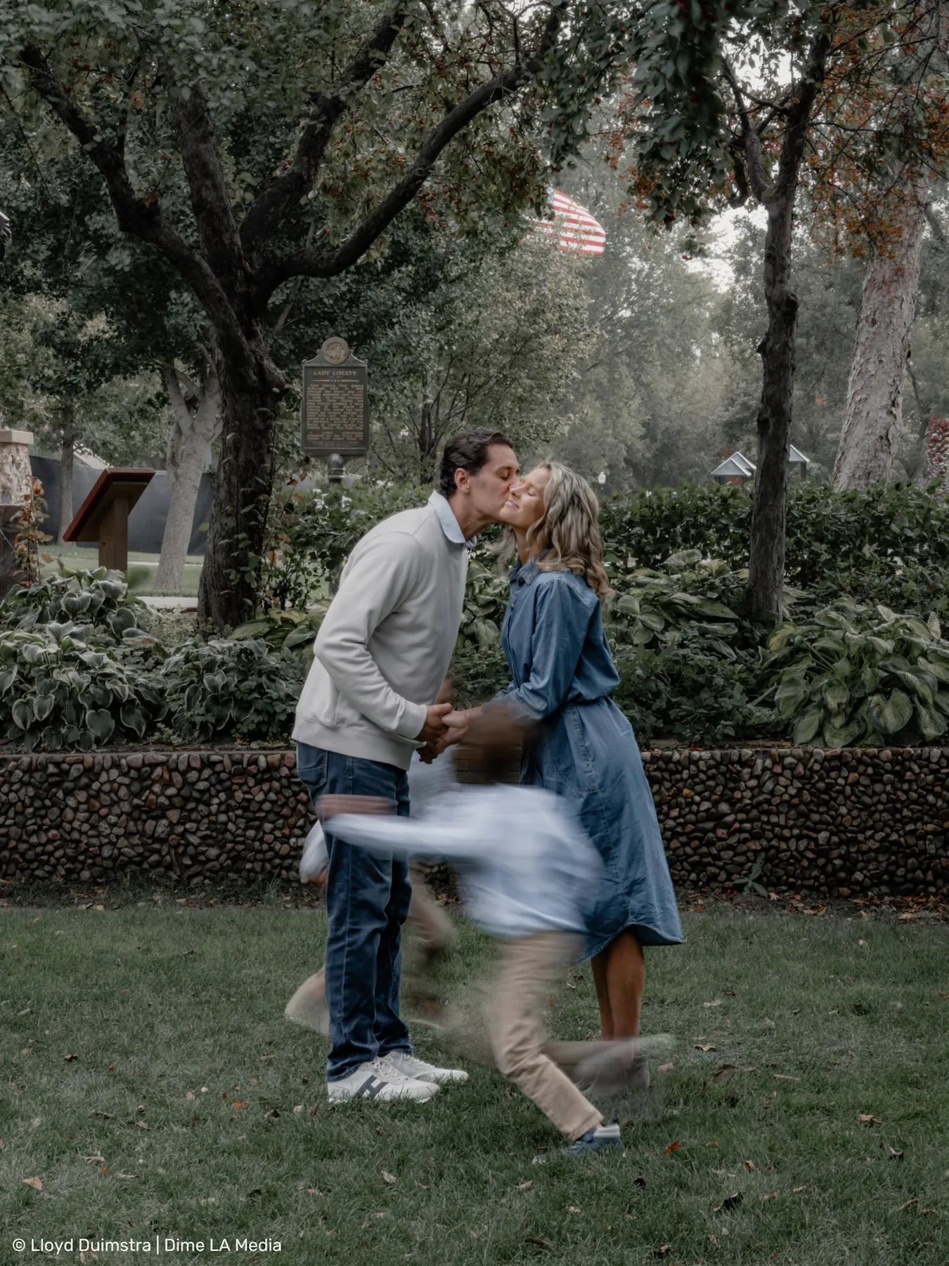 Parents kissing while the boys run circles around them