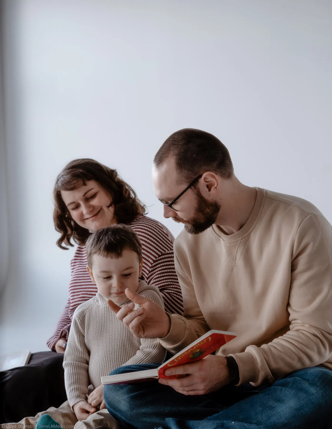 Dad reading a picture book to his son during the maternity session