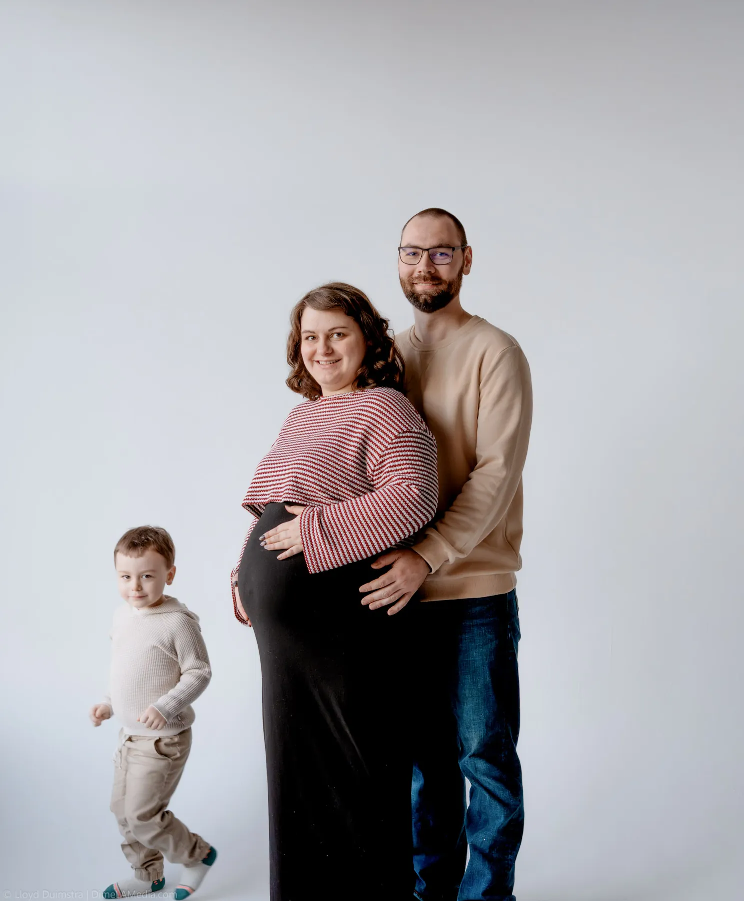 Toddler reaching up to touch the baby bump