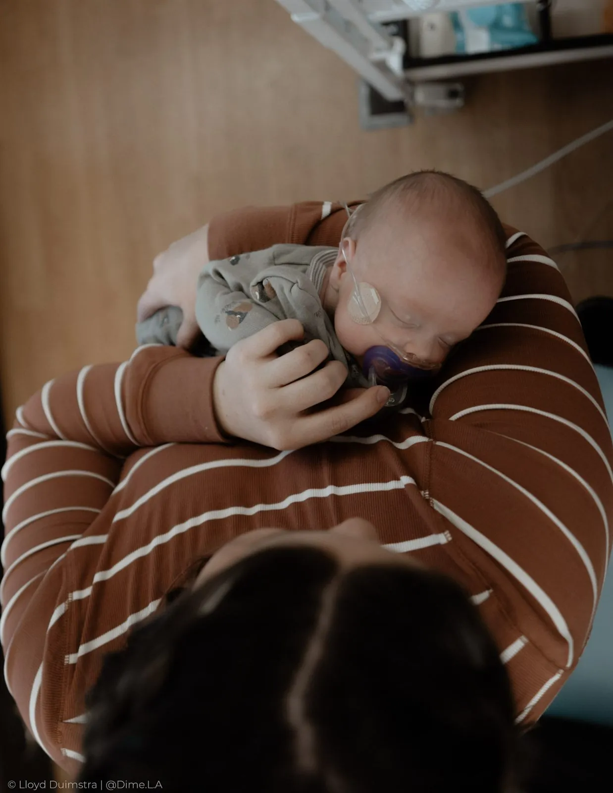 Newborn draped over mom’s arm, fast asleep