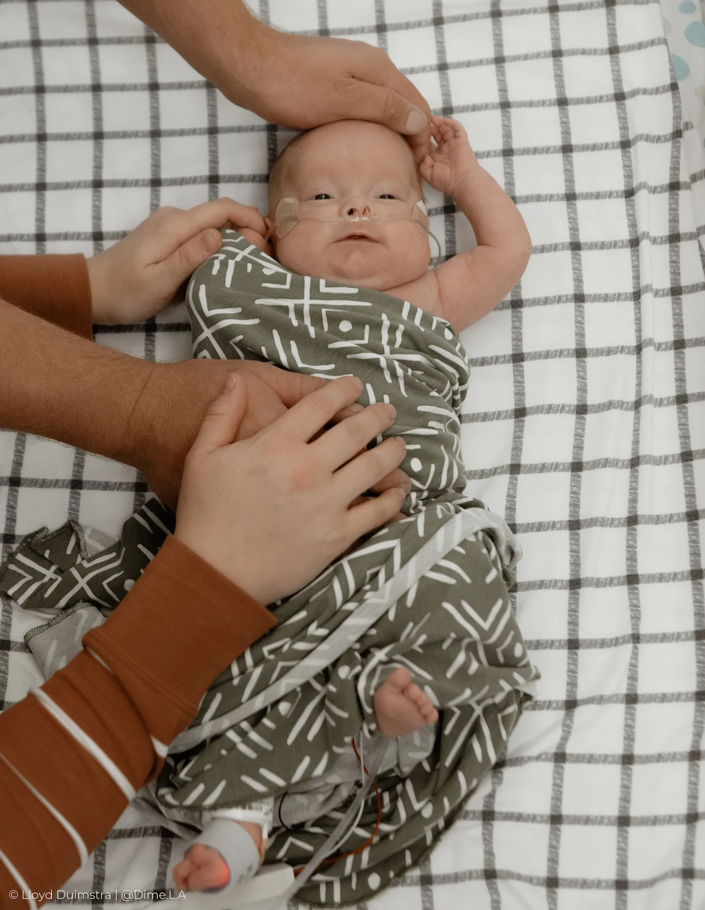 Mom cradling her NICU newborn dressed in sage green